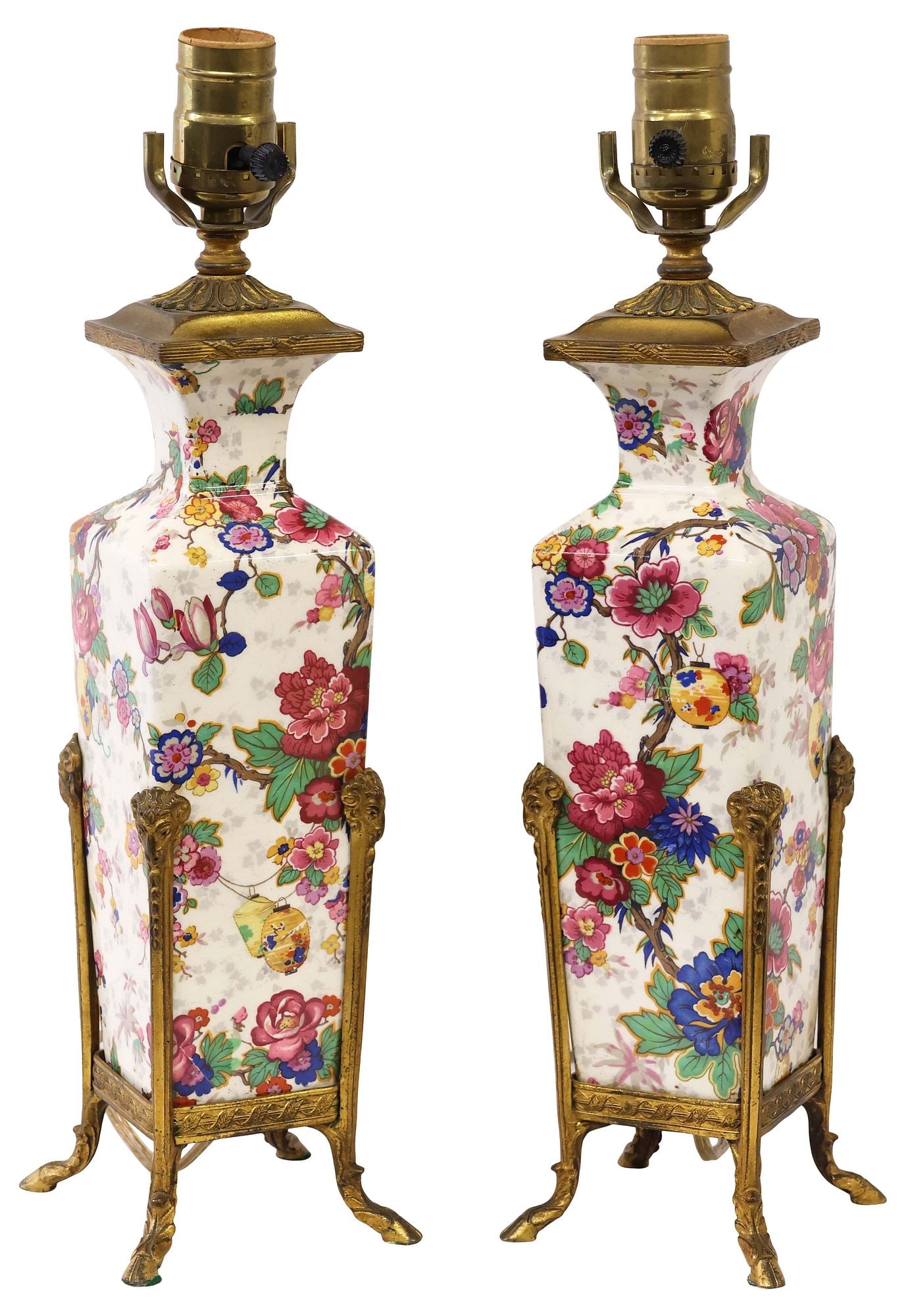 (2) FRENCH PORCELAIN SINGLE LIGHT TABLE LAMPS IN THE ASIAN TASTE: (pair) French porcelain and gilt metal table lamps, 20th c., decorated in the Asian style with polychrome flowering branches and lanterns, gilt metal frame with ram's head terminals and hooved feet,