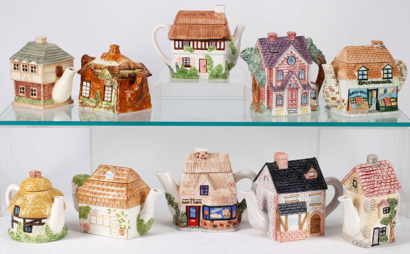 (10) NOVELTY ARCHITECTURAL HOUSE-FORM CERAMIC TEAPOTS: (lot of 10) Ceramic novelty teapots, each in the form of an architectural house or shop facade, various styles and makers, including Village Square Collectibles, Price Kensington, and OCI Philippines,