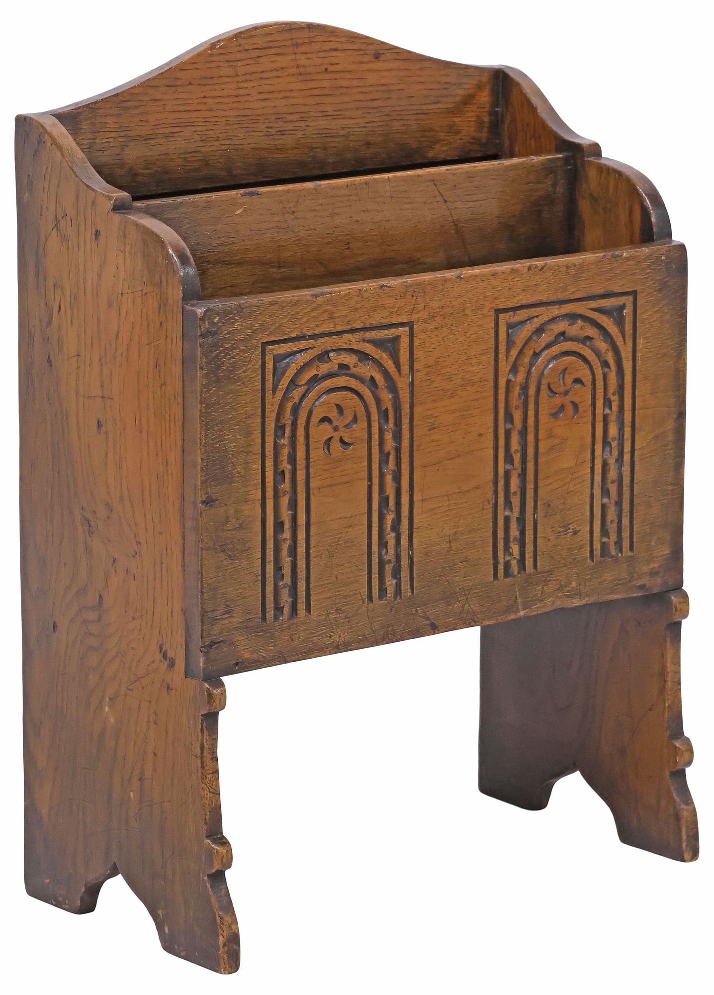 ENGLISH JACOBEAN STYLE CARVED OAK MAGAZINE RACK / STAND: English Jacobean style carved oak magazine rack, 20th c., having shaped top, over two divided storage compartments, with geometric archway motifs, rising on bracket feet, approx 22"h, 15.5"w, 7.5"d,