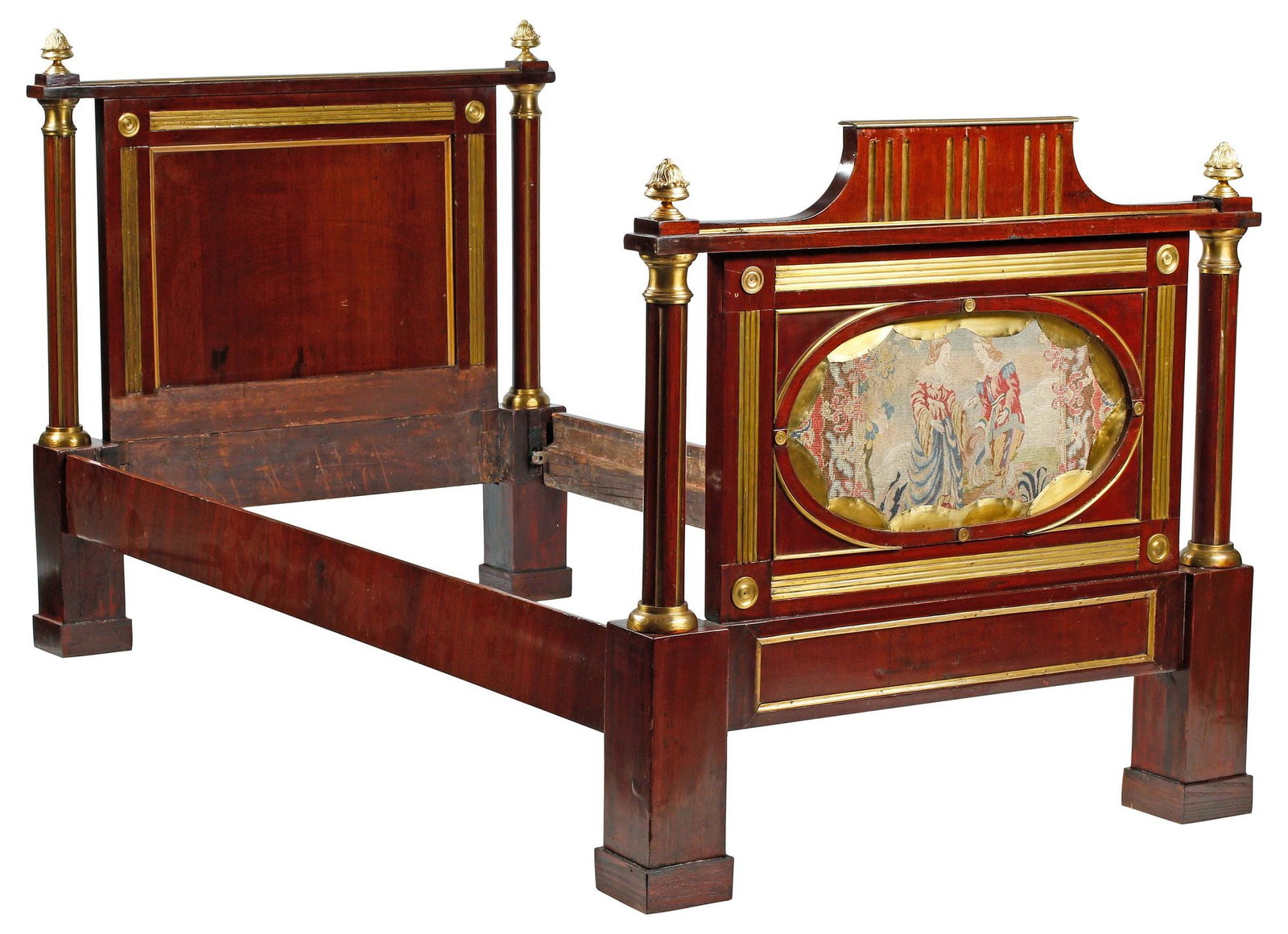 RUSSIAN NEOCLASSICAL STYLE NEEDLEPOINT-UPHOLSTERED MAHOGANY BED: Russian Neoclassical style brass-mounted mahogany bed, early 19th c., each end with fluted columnar posts surmounted by foliate finials, the footboard with needlepoint upholstery panel in oval cartouc