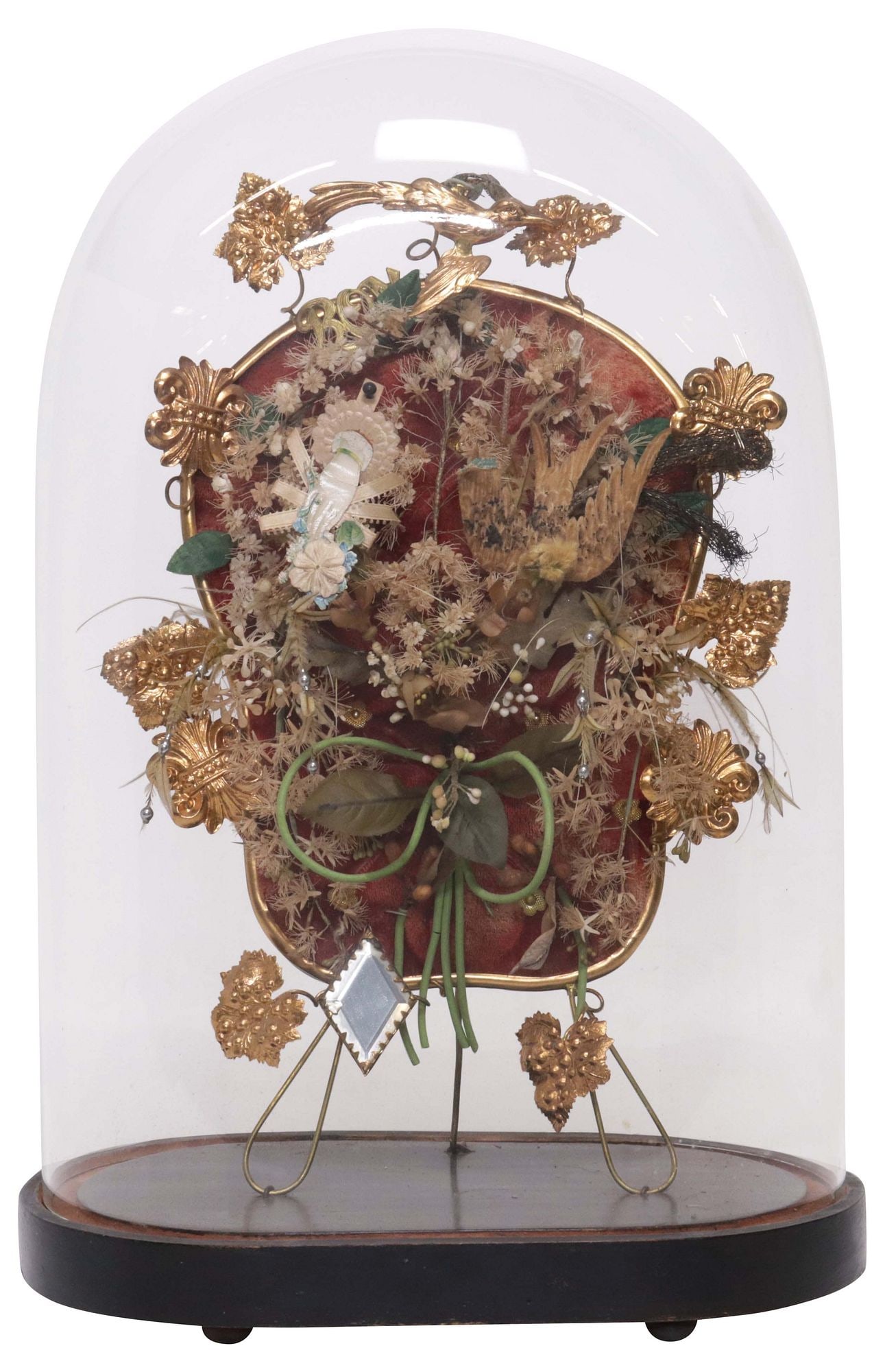 FRENCH GLOBE DE MARIEE / BRIDE'S GLOBE IN GLASS CLOCHE: French globe de mariee/ bride's globe, late 19th c., glass cloche/ dome on ebonized base, enclosing silk flowers, gilt-metal foliates, and small beveled mirror plate, on tufted cushion, approx 16"h, 1