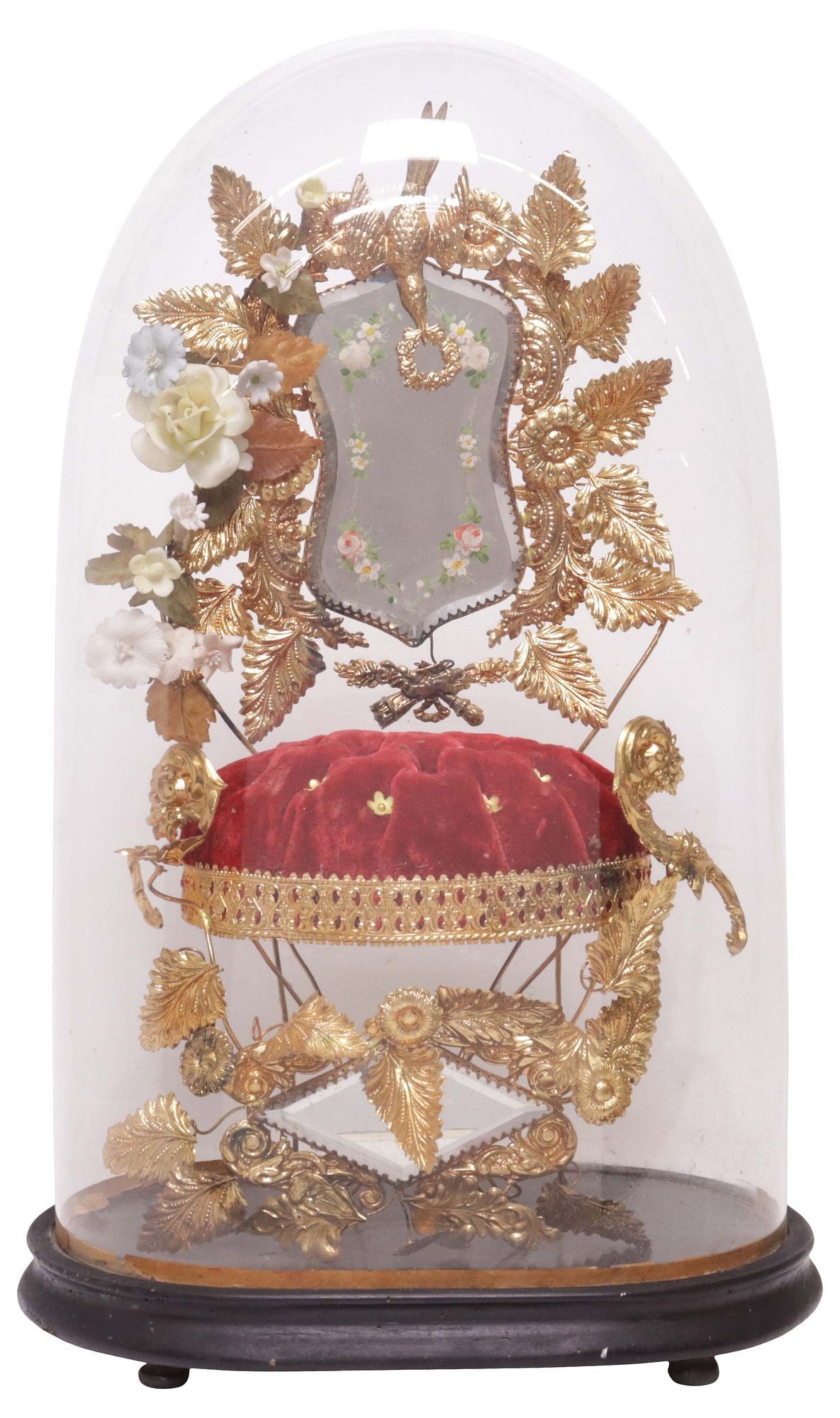 FRENCH GLOBE DE MARIEE / BRIDE'S GLOBE IN GLASS CLOCHE: French globe de mariee/ bride's globe, late 19th c., glass cloche/ dome on ebonized base, enclosing gilt-metal foliates and porcelain flowers, central paint-decorated mirror plate, on tufted cushion, 