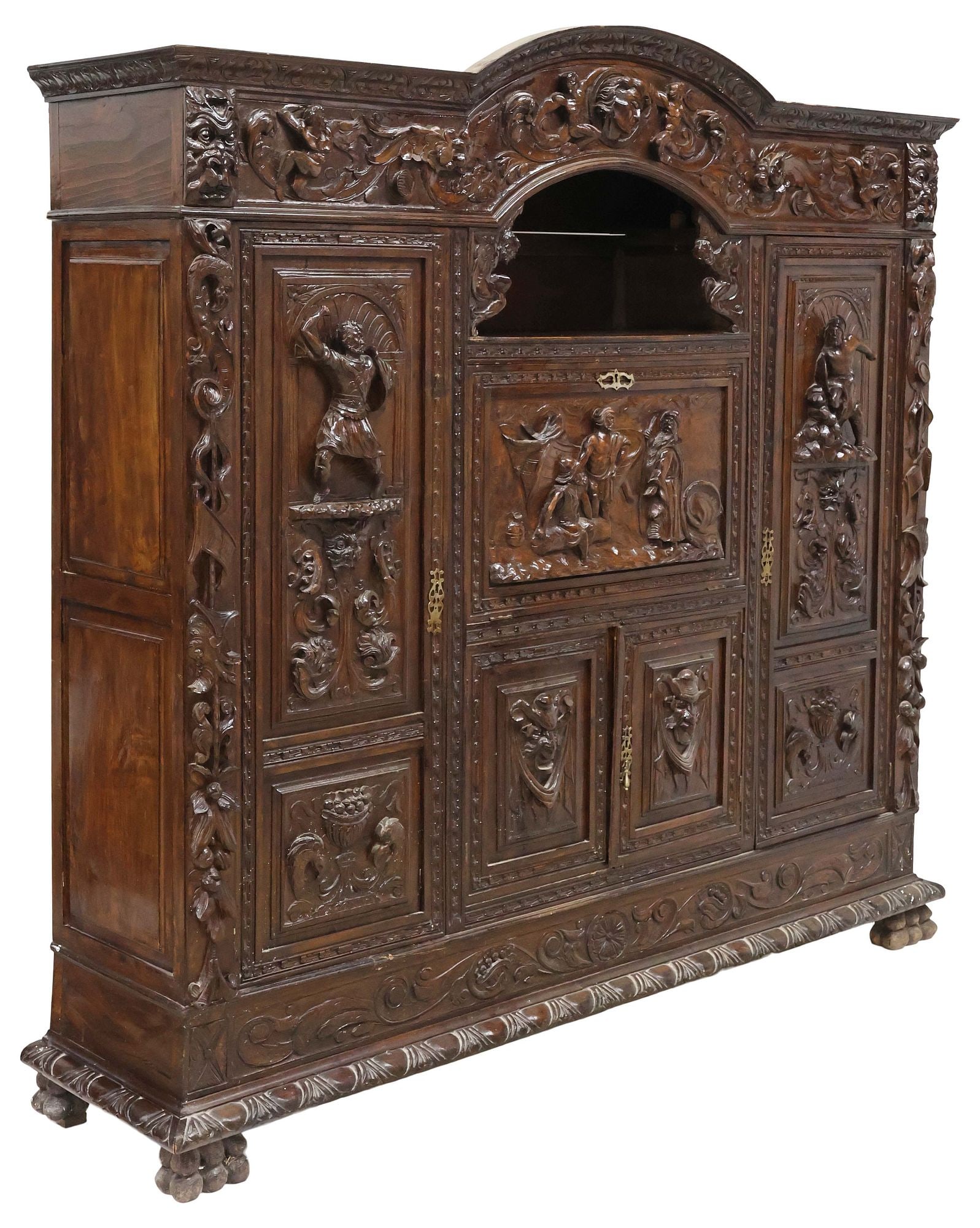 SPANISH RENAISSANCE REVIVAL HIGHLY-CARVED WALNUT SECRETARY BOOKCASE: Spanish Renaissance Revival walnut secretary bookcase, late 19th c., having arched crest with scrolling foliate frieze, the case profusely decorated with allegorical figures, grotesque masks, and frui