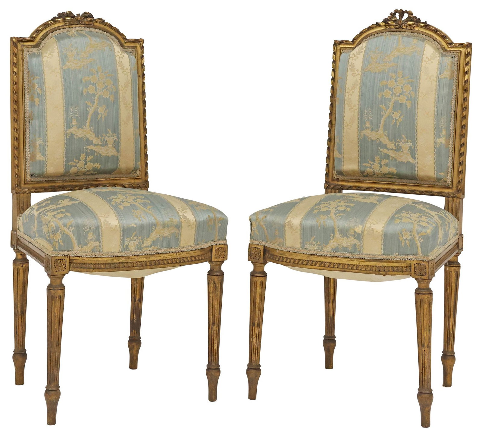 (2) FRENCH LOUIS XVI STYLE SILK-UPHOLSTERED GILTWOOD SIDE CHAIRS: (pair) French Louis XVI style giltwood side chairs, early 20th c., each having floral crest, over padded back and seat in a striped silk jacquard upholstery, rising on fluted tapered legs, one with lo