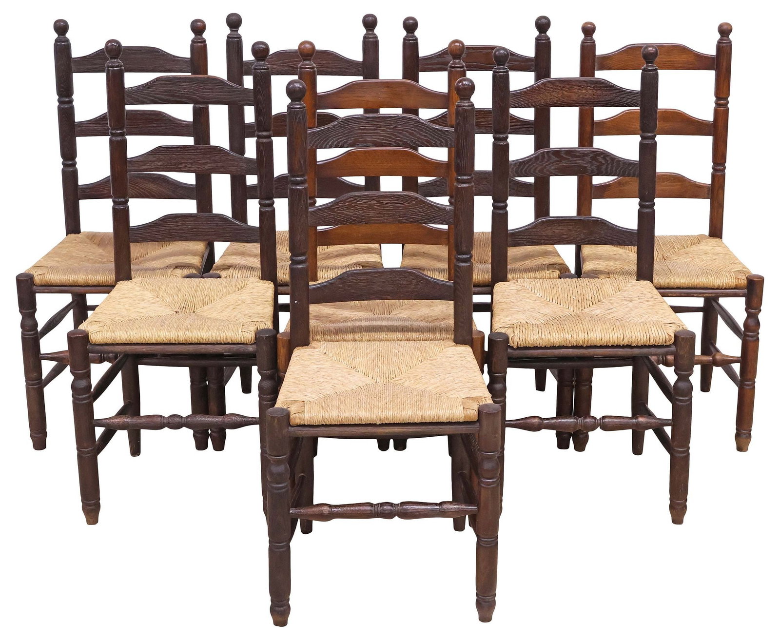 (8) SPANISH PROVINCIAL CARVED OAK RUSH-SEAT DINING CHAIRS: (lot of 8) Spanish ladder-back oak dining chairs, 19th c., having turned finials, woven rush seat, rising on stretcher-joined turned supports, finish with tonal variation, approx 41"h, 18"w,