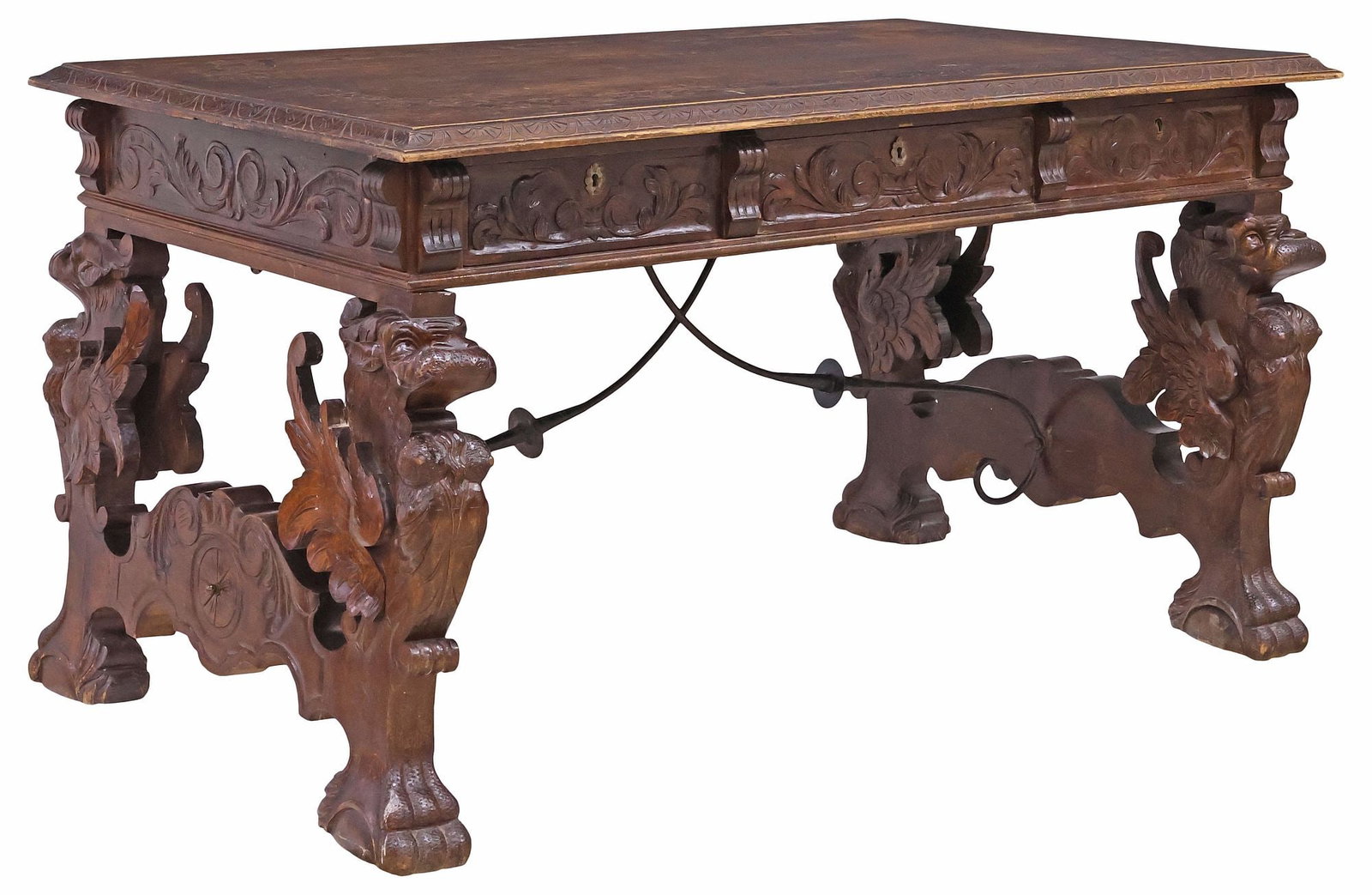 SPANISH RENAISSANCE REVIVAL CARVED OAK WRITING DESK: Spanish Renaissance Revival carved oak library table or writing desk, late 19th c., having rectangular top with foliated trim, over three drawers, rising on trestle base with protruding figural grotes
