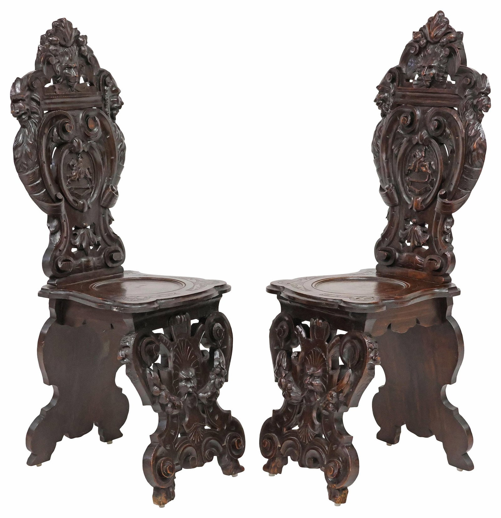(2) ITALIAN RENAISSANCE REVIVAL CARVED WALNUT HALL CHAIRS: (pair) Italian Renaissance Revival carved walnut hall chairs, late 19th c., each having scrolled back with foliated crest and central mask, over rider on horseback in oval cartouche, rising on pierced