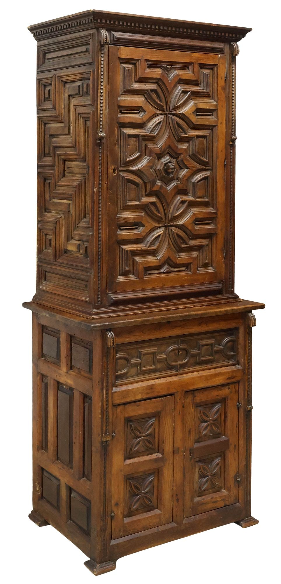 RUSTIC SPANISH BAROQUE STYLE CARVED WALNUT CABINET: Rustic Spanish Baroque style carved walnut cabinet, 19th c., of married construction, having geometric and stylized floral carvings, central door revealing fixed-height shelving, the lower rectangular