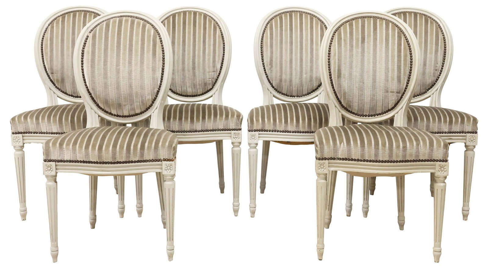 (6) FRENCH LOUIS XVI STYLE WHITE-PAINTED & UPHOLSTERED DINING CHAIRS: (lot of 6) French Louis XVI style white-painted side chairs, early 20th c., each having oval medallion back and padded seat in striped gray fabric upholstery, with nail-head trim, on tapering fluted l