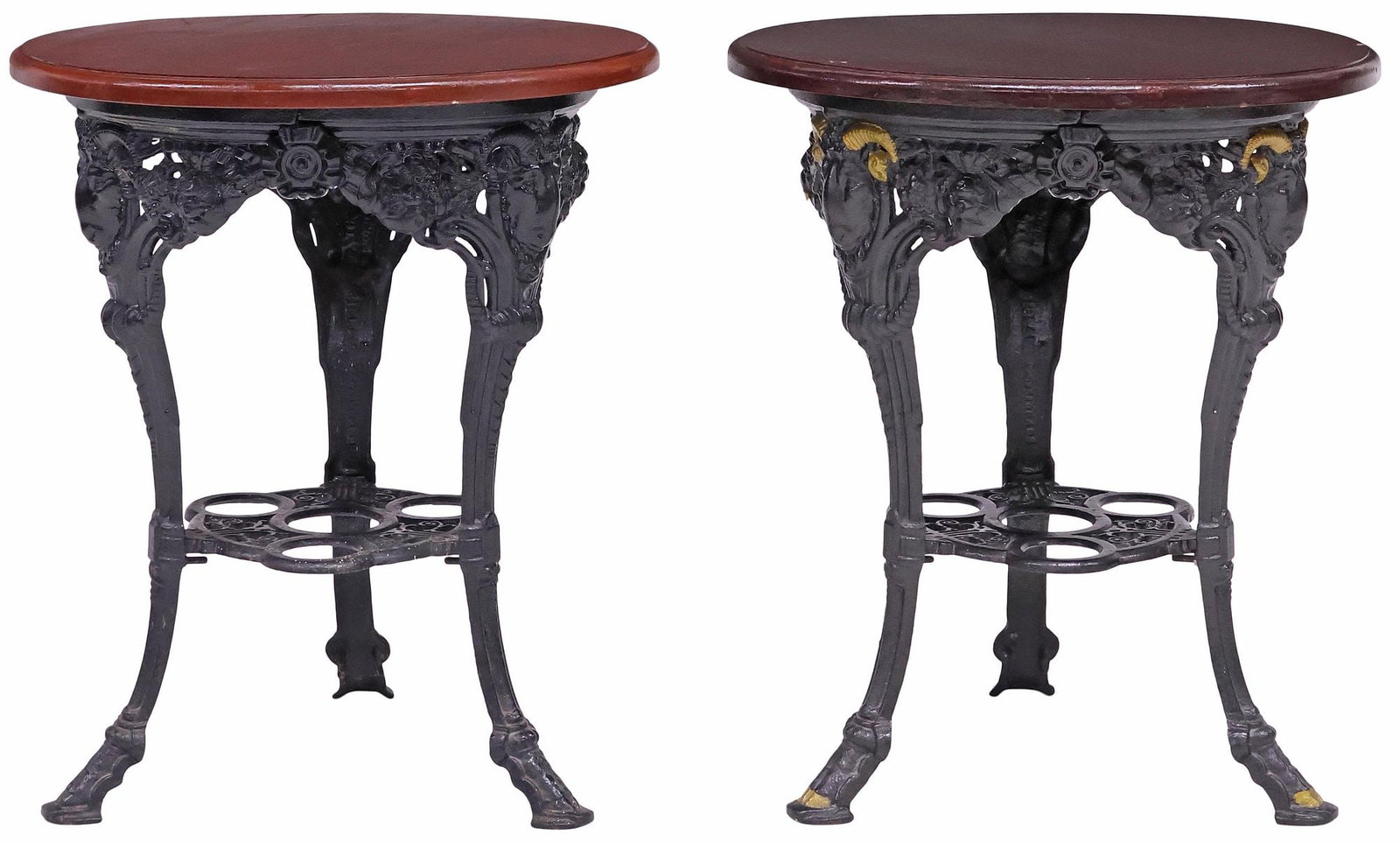 (2) ENGLISH MAHOGANY-TOP PAINTED CAST IRON PUB TABLES: (lot of 2) English pub tables, early 20th c., a near pair, each with circular mahogany top, raised on black-painted cast iron base with ram's masks and fruit motifs, (one) with gilt-painted accents,