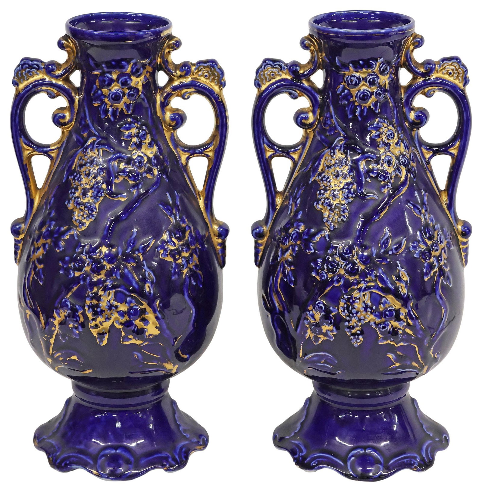 (2) ENGLISH HJ CAMEO WARE PARCEL-GILT & COBALT POTTERY VASES: (pair) English parcel-gilt and cobalt glazed ceramic vases, HJ Cameo Ware, 20th c., each with dual scrolled handles, raised foliates and floral motifs, marked underfoot, approx 13.5"h, 6"w, 5.75"d,