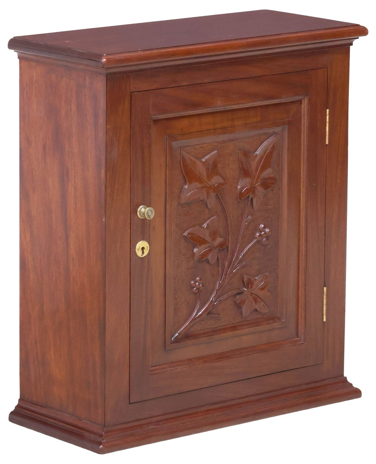 DIMINUTIVE ENGLISH CARVED MAHOGANY TABLETOP CABINET, 22"H: Small English mahogany tabletop cabinet, early 20th c., having molded cornice, over paneled door with carved branch of foliates, enclosing fixed-height shelving, on plinth base, approx 22"h, 19.5"w,