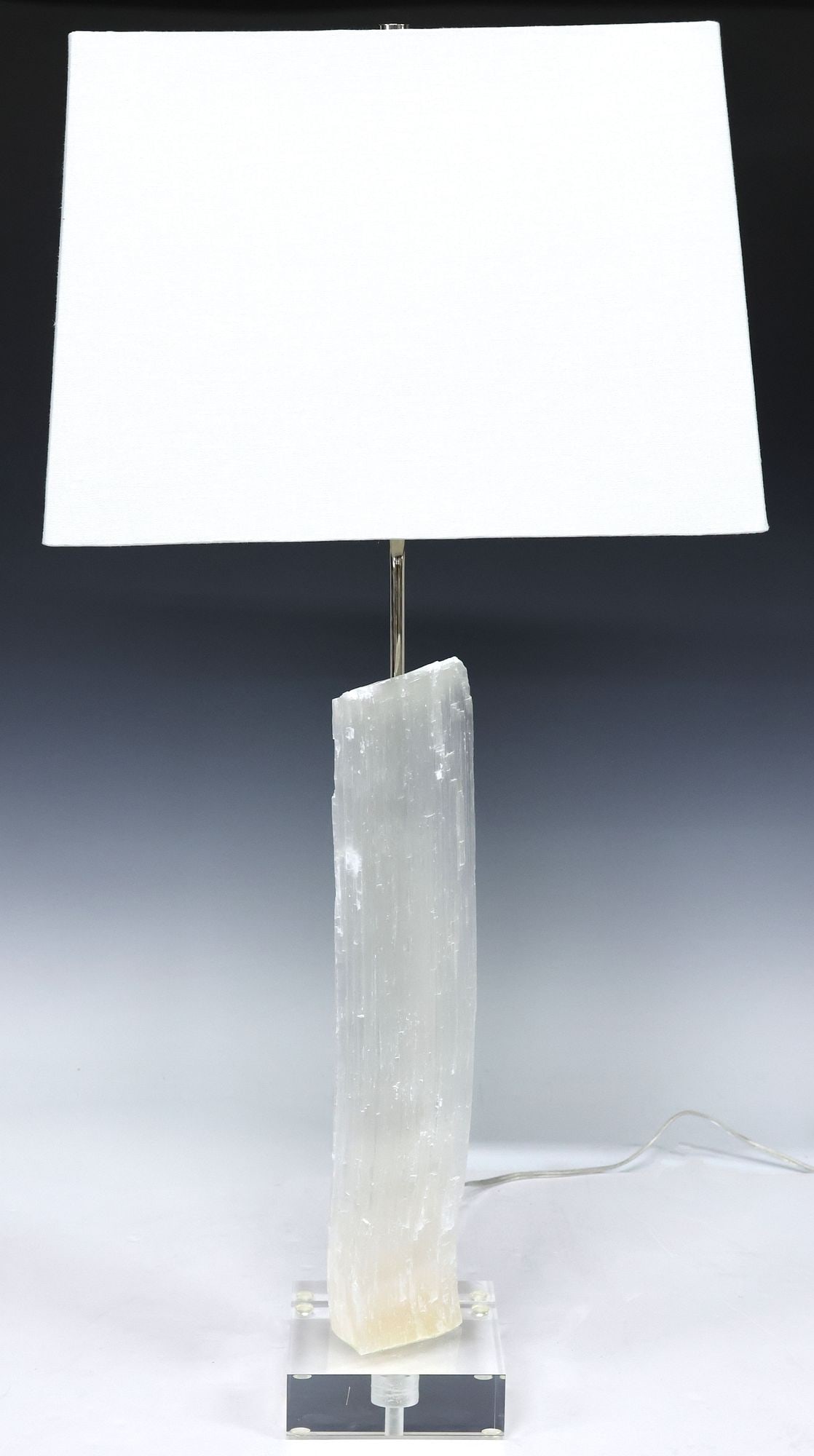 GEOLOGICAL MOROCCAN SELENITE SPECIMEN 1-LIGHT TABLE LAMP: Geological Moroccan selenite specimen, now fashioned as a single-light table lamp, on acrylic base, accompanied by linen shade, observed operating, specimen: approx 16 3/8"h, 3.5"w, 2.5"d, overall wit