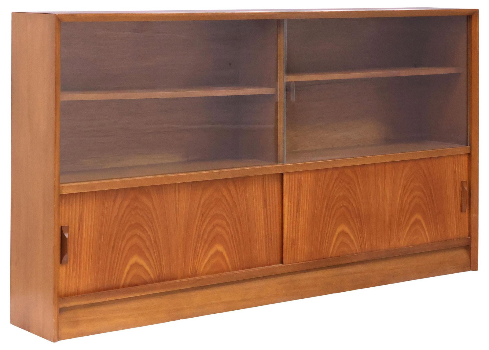 HERBERT E. GIBBS MID-CENTURY MODERN TEAK & GLASS BOOKCASE: Mid-century teak low bookcase, Herbert E. Gibbs, London, c.1960s, rectangular case with pair of sliding glass doors, enclosing adjustable shelving, above pair of sliding panel doors, revealing open in