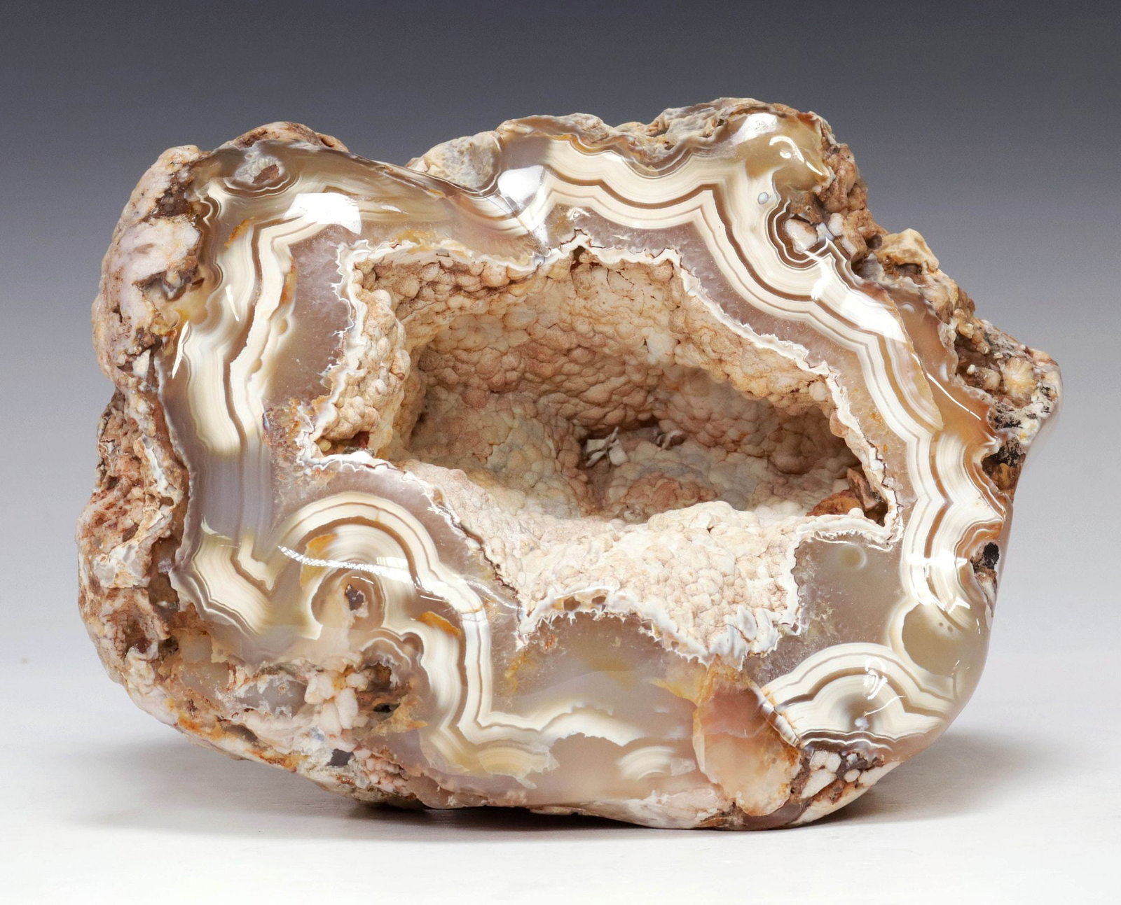 GEOLOGICAL BANDED AGATE SPECIMEN, MADAGASCAR: Geological polished agate geode, Madagascar, with white and brown banding, and calcified botryoidal inclusions, approx 5.5"h, 7"w, 6.5"d, 8lbs**Provenance: Treasures from the vaults of a Dallas design