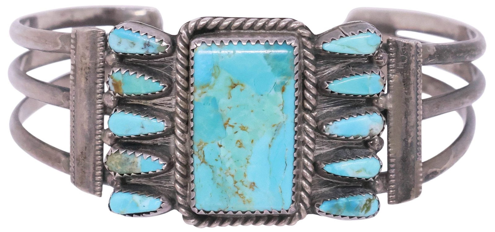 NATIVE AMERICAN STERLING & TURQUOISE CABOCHON CUFF BRACELET: Native American sterling silver cuff bracelet, rectangular bezel-set turquoise stone in twisted rope surround, framed by (ten) small turquoise cabochons, on split shank band, hallmarked sterling with 