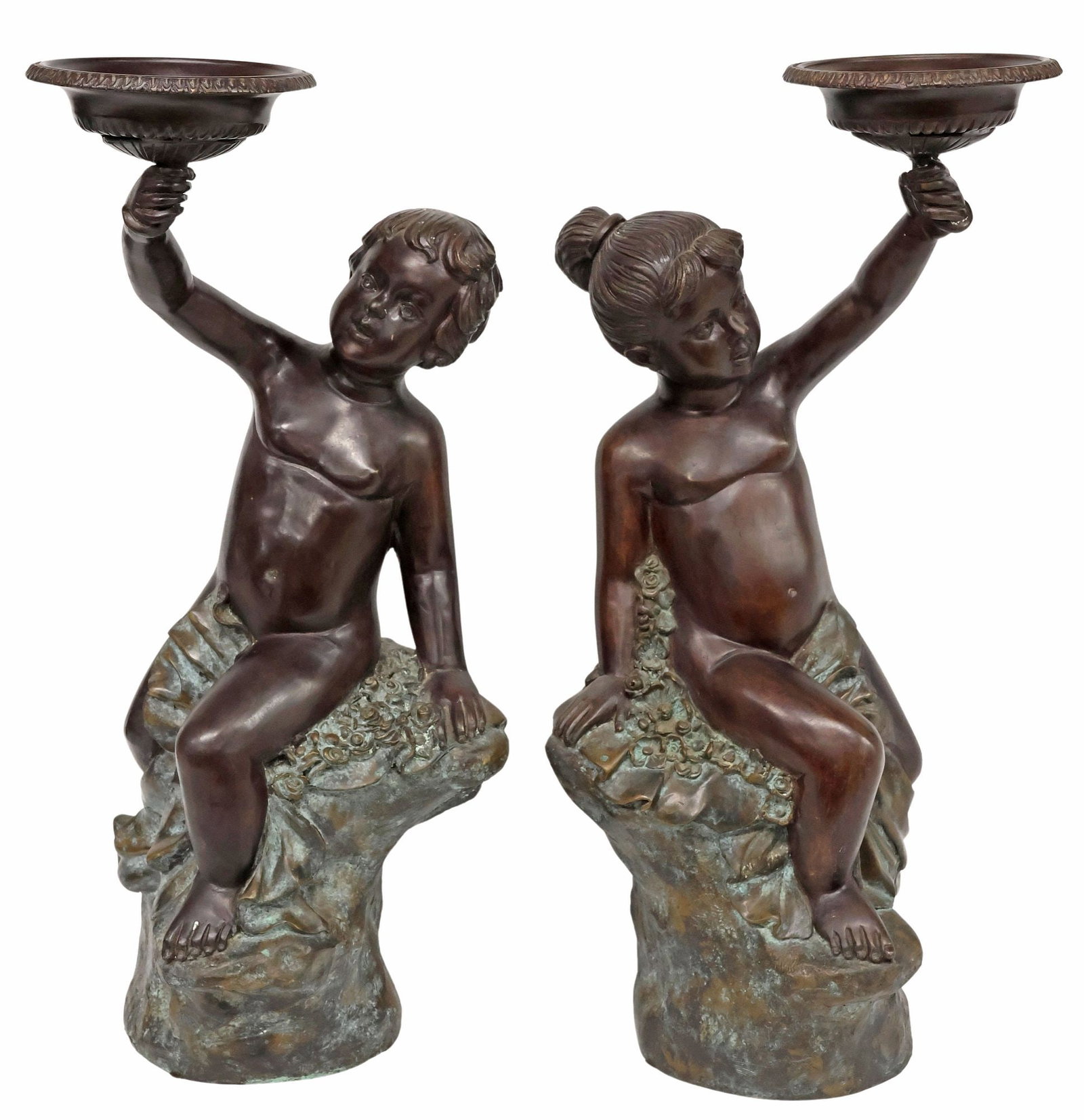 (2) LARGE MAITLAND-SMITH PATINATED BRONZE FIGURAL CANDLE HOLDERS: (pair) Patinated bronze figural candle holders, Maitland-Smith, late 20th c., modeled as a young boy and a girl hoisting lobed urns, each sitting atop a naturalistic rocky outcrop with drapery and ros