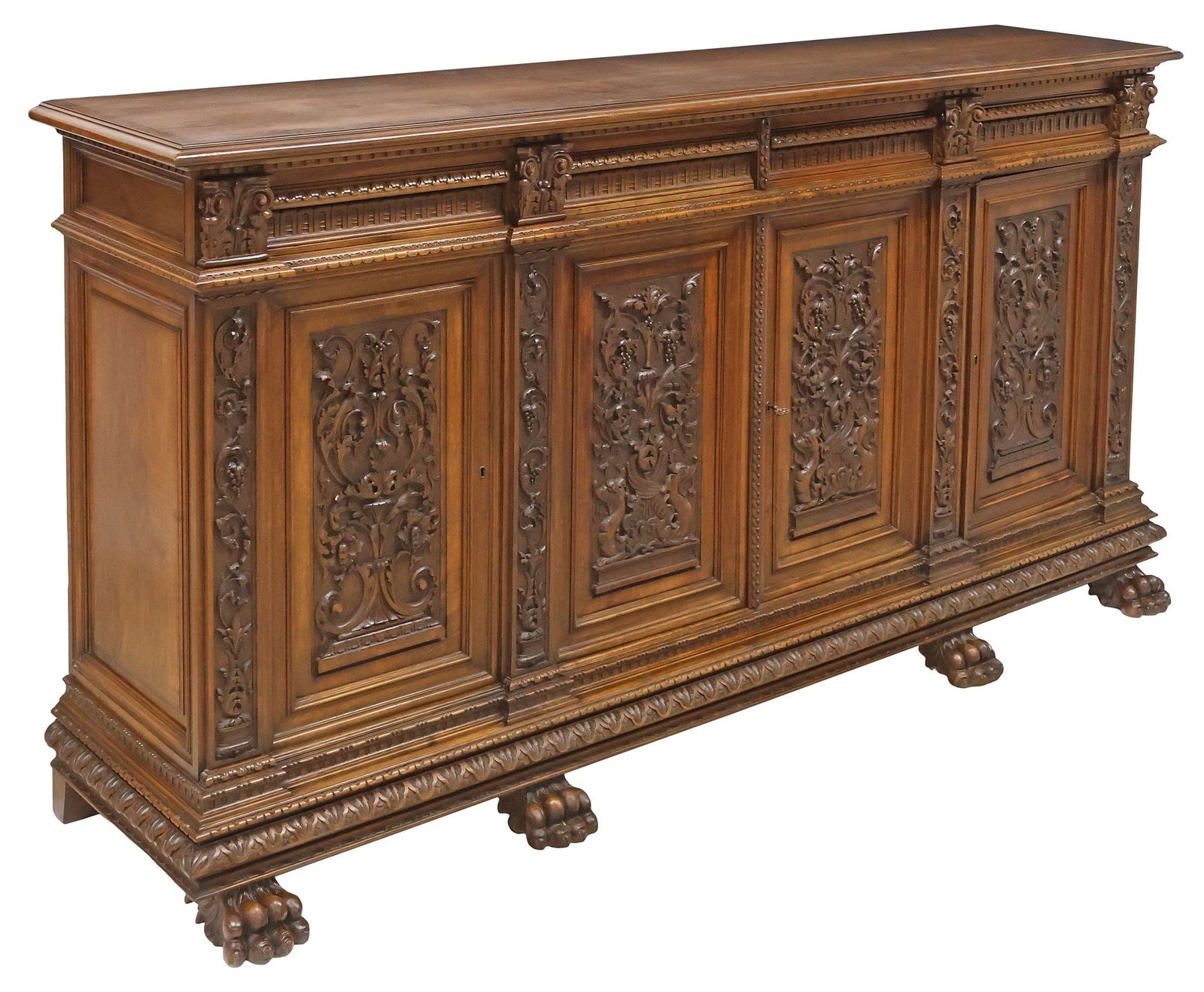 ITALIAN RENAISSANCE REVIVAL CARVED WALNUT SIDEBOARD: Italian Renaissance Revival carved walnut sideboard, early 20th c., having rectangular top with dentil-molded trim, above four arcaded drawers, and four paneled doors with abundant scrollwork and foli