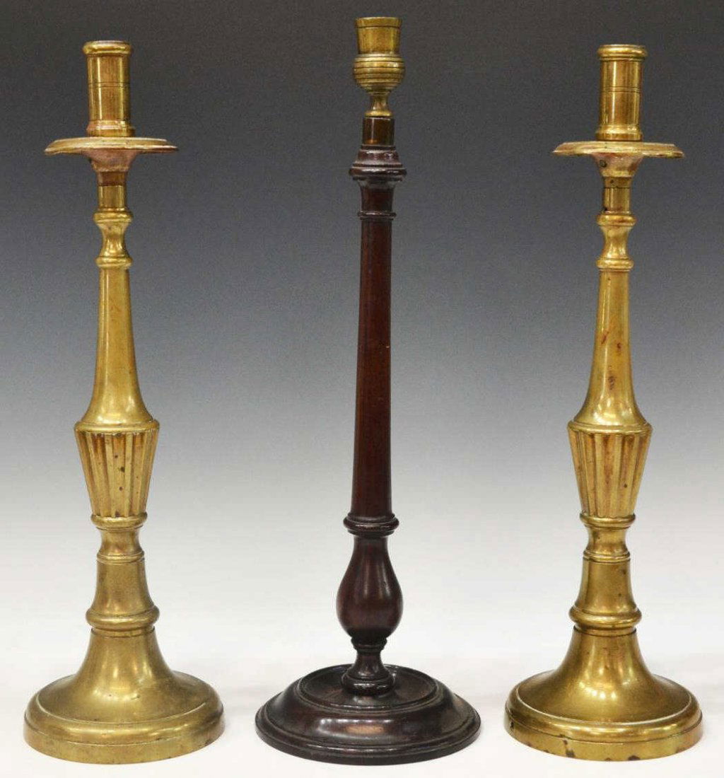 (3) GEORGIAN MAHOGANY & ANTIQUE BRASS CANDLESTICKS: (lot of 3) Antique candlesticks: (pair) tall brass sticks, likely 18th/19th c., drilled as pictured, 17"h; (1) Georgian mahogany candlestick having gilt brass cup and weighted base, 17.5"h, approx 6.7