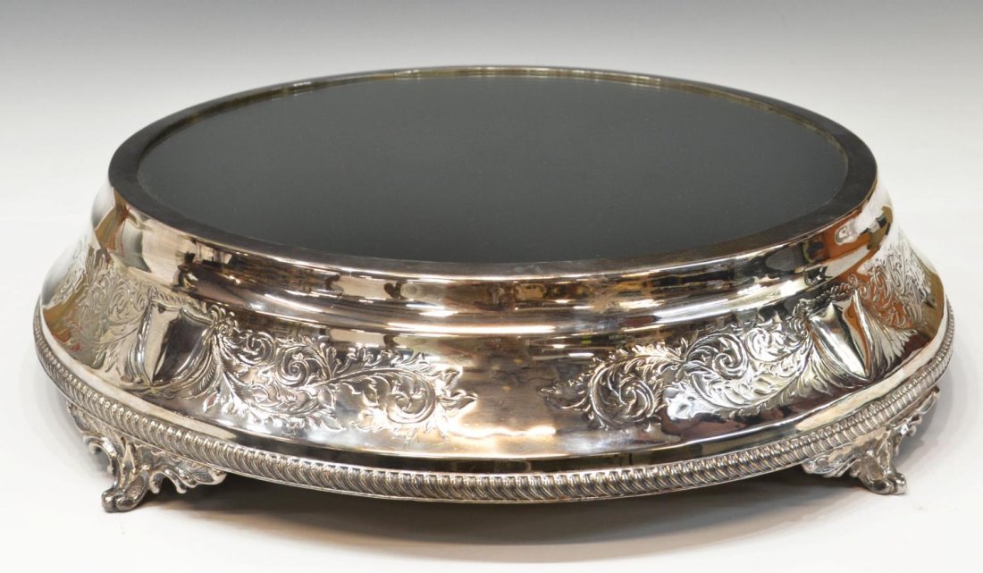LARGE GEORGE V STYLE SILVERPLATE PLATEAU MIRROR: Large George V style silverplate plateau mirror of circular form, engraved foliate scrolls center four shield-form cartouches, fitted with a conforming a mirrored plate, gadrooned borders at the base 