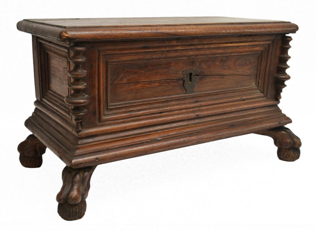 CONTINENTAL CARVED WALNUT CASKET ON PAW FEET: Continental carved walnut casket, c. 1900, the rectangular top with two inlays of diamond form, opening to storage, loop iron hinges, wood support, the facade featuring turned pilasters and central lo
