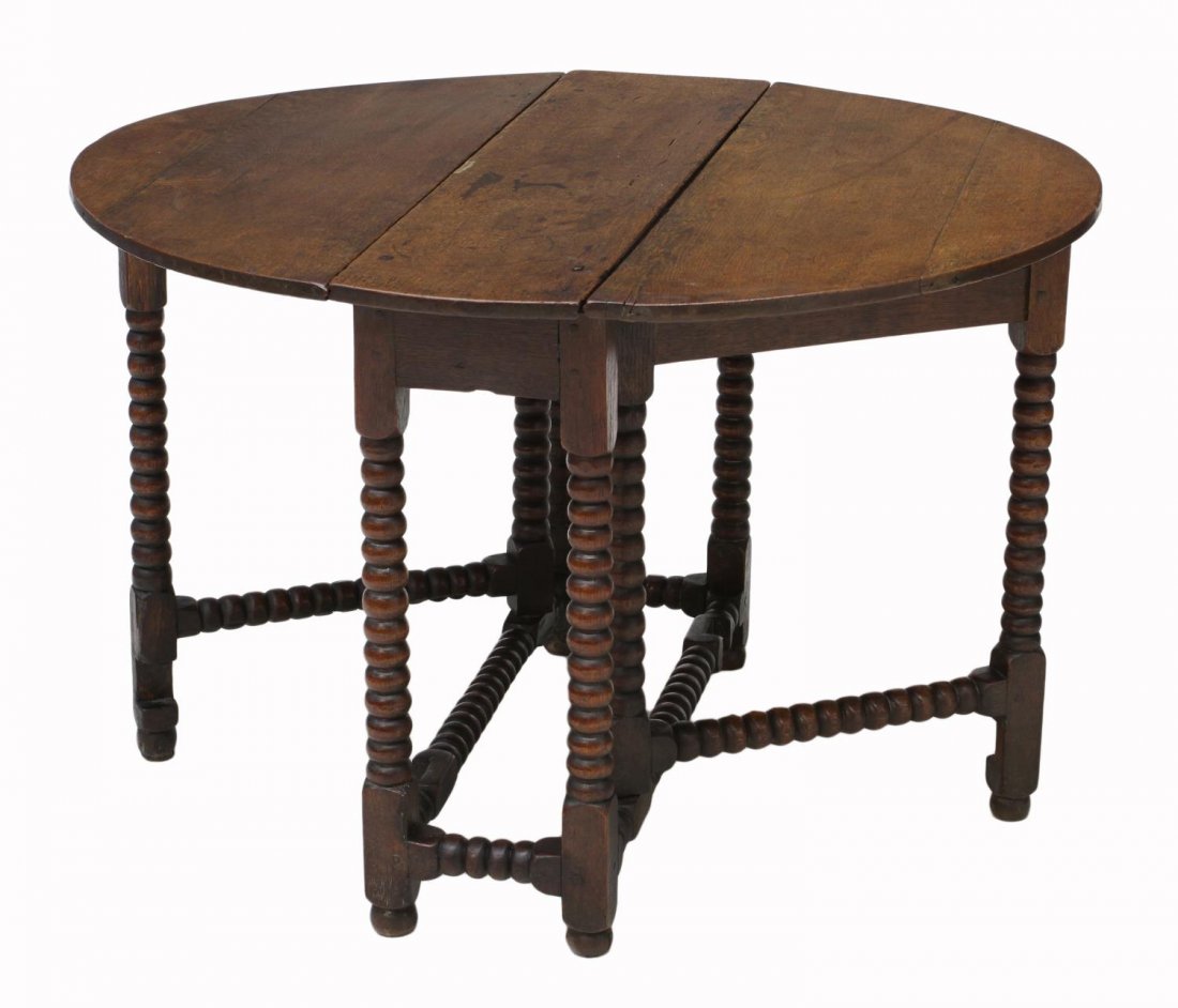 ANTIQUE ENGLISH OAK DROP LEAF TABLE: English oak drop leaf table, 19th c., the top rising on stretcher joined spool gate and fixed legs with bun feet, top up: 40.75"w, top down: 27.5"h, 11.25"w, 35.75"l Start Price: $100.00