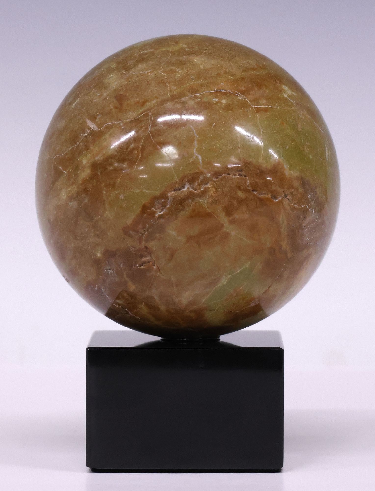 GEOLOGICAL GREEN MARBLE SPHERE ON BLACK MARBLE BASE: Geological green marble sphere, on black marble base, specimen: approx 4.5"diam, overall: approx 6"h, 4.5"w, 4.5"d, 3.5lbs