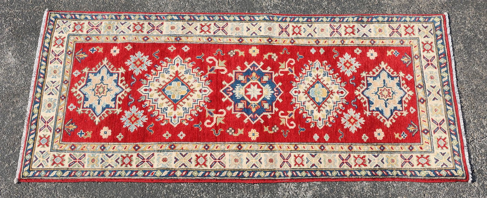 ESTATE HAND-TIED KAZAK RUG, 6'5" X 2'8": Estate hand-tied Kazak rug, approx 6'5"l, 2'8"w **Please Note: All of the rugs offered in this auction would likely benefit from a professional cleaning. Estate rugs may show some wear and