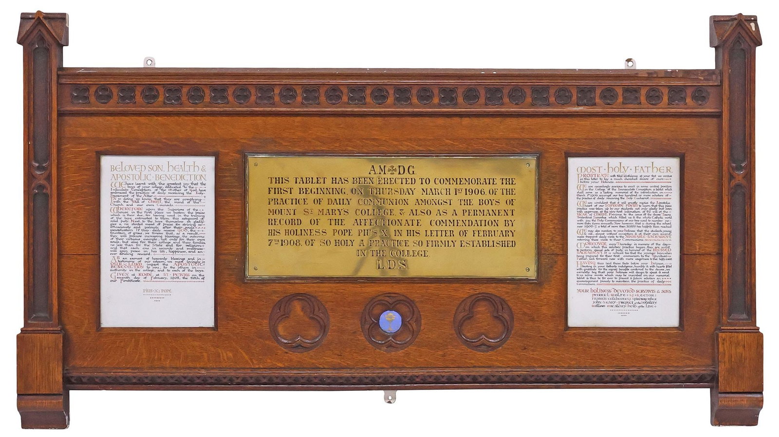 GOTHIC REVIVAL OAK & BRASS RELIGIOUS WALL PLAQUE, ST. MARY'S COLLEGE, 34.5" X 62": Large Gothic Revival carved oak wall-hanging plaque, early 20th c., rectangular frame with raised architectural spires, among quatrefoil and trefoil tracery motifs, centering engraved brass plate, wit