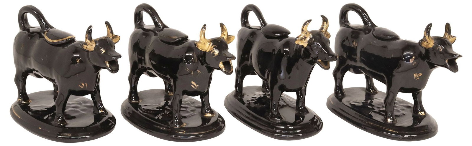 (4) ENGLISH STAFFORDSHIRE JACKFIELD GLAZE COW CREAMERS: (lot of 4) English Staffordshire cow creamers, 20th c., each in a Jackfield black glaze, with parcel-gilt features, rising on ovular base, largest: approx 5.75"h, 7.25"w, 3 5/8"d, 4.75lbs total