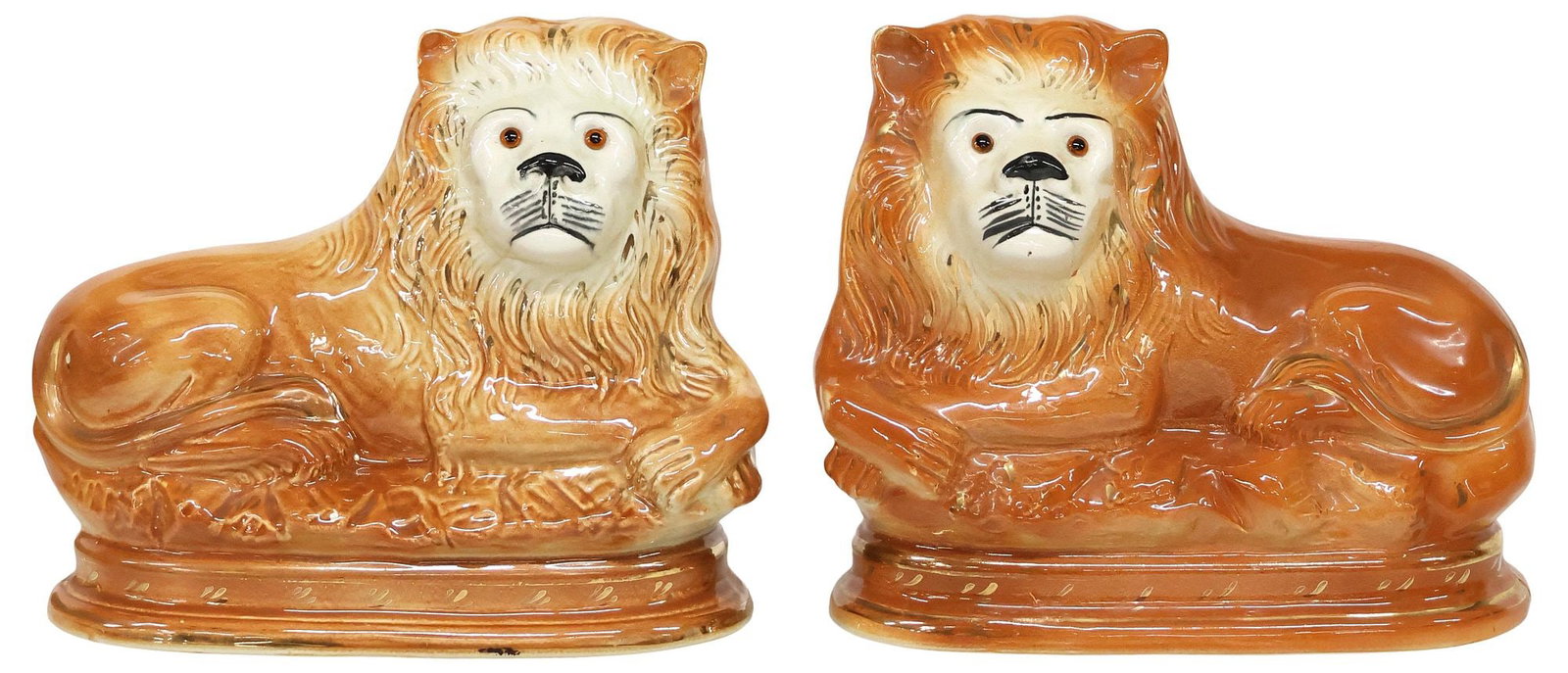 (2) ENGLISH VICTORIAN STAFFORDSHIRE RECUMBENT LION FIGURES: (pair) English Victorian Staffordshire pottery figures, late 19th c., each modeled as a recumbent lion, with inset glass eyes and painted features, remnants of parcel-gilt decoration, seated upon natu