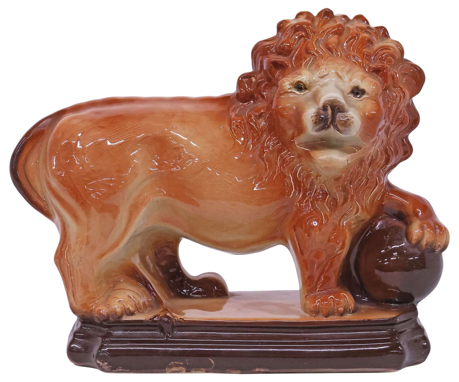 LANCASTER & SONS (ATTRIB.) STAFFORDSHIRE LION MANTEL FIGURE: English Staffordshire mantel figure, attributed to Lancaster & Sons, Hanley, early 20th c., modeled as a russet-colored lion with paw on ball, with inset glass eyes, standing atop a stepped plinth, un