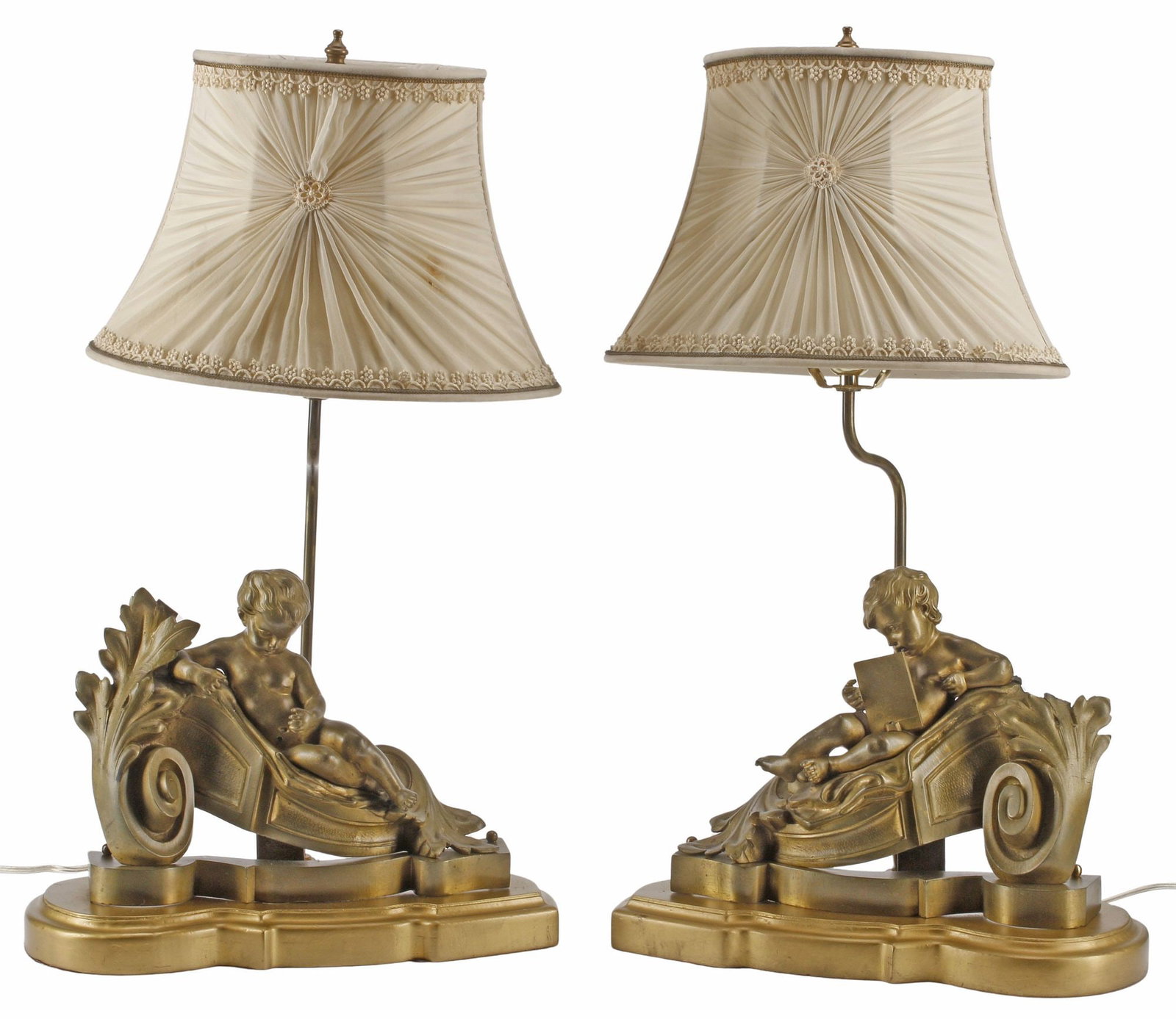 (2) LOUIS XV STYLE ORMOLU 'PUTTI' CHENETS, NOW AS 1-LT TABLE LAMPS: (pair) Louis XV style bronze dore fireplace chenets/ andirons, now mounted as one-light table lamps, each modeled as a putto reclined against foliated scroll, on platform base, accompanied by pleated 