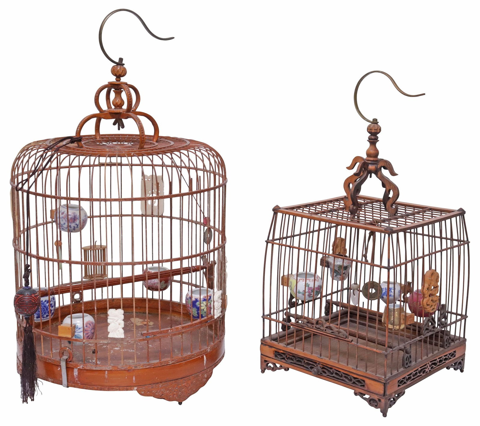 (2) CHINESE BAMBOO & HARDWOOD BIRDCAGES WITH PORCELAIN FEEDERS: (lot of 2) Chinese hollowed bamboo and hardwood bird cases, exterior of each adorned with decorative carved clips with animals and figural scenes, interiors with five porcelain bird feeders of varied 