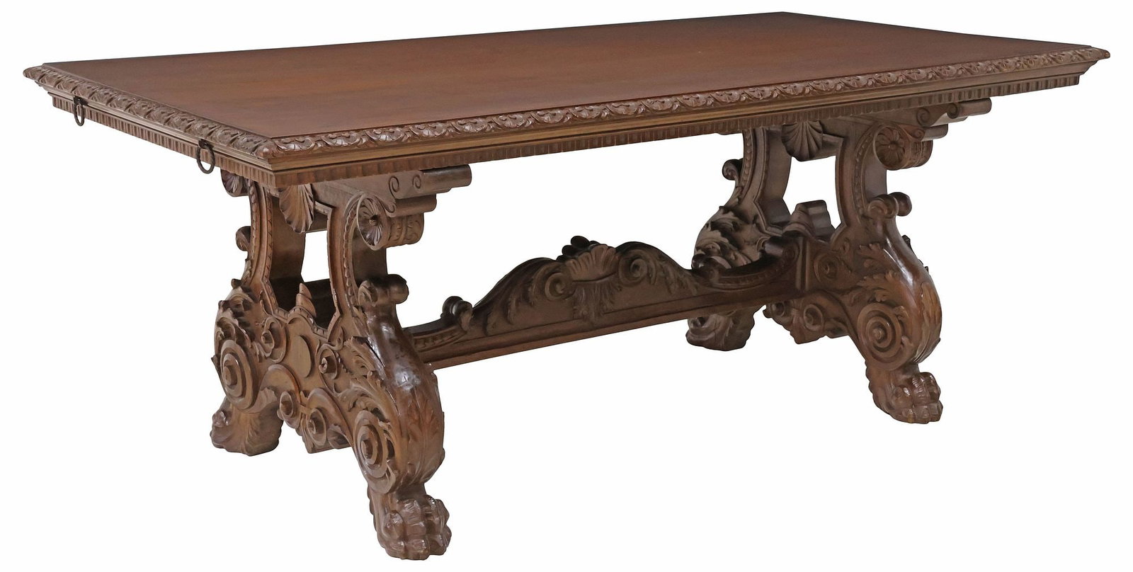 ITALIAN RENAISSANCE REVIVAL CARVED WALNUT EXTENSION DINING TABLE: Italian Renaissance Revival carved walnut extension dining table, early 20th c., rectangular top with volute trim, dual iron slides to accommodate leaves, raised on stretcher-joined trestle supports