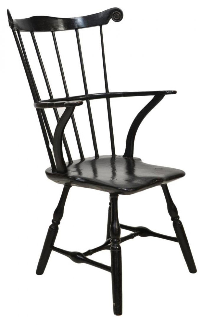 ANTIQUE SIX SPINDLE WINDSOR ARM CHAIR: American Windsor comb back arm chair in black paint, early 19th c., the shaped crest rail ending in scrolls embracing six vertical back spindles with the center rail terminating as arms, rising on str