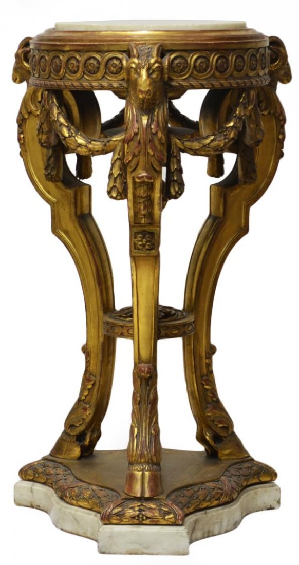 LOUIS XVI STYLE GILT & MARBLE CARVED STAND: Louis XVI style gilt and patinated wood stand having a circular inset marble top, a carved frieze with ram's heads joined by foliate garlands, supported on three cabriole legs, with hoof feet, joined 