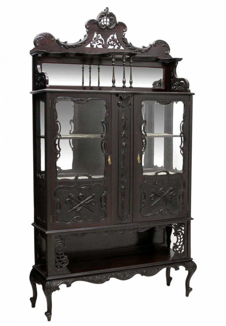 FRENCH STYLE CARVED EBONIZED MIRRORED ETAGERE: French style etagere, 19th c., an ebonized cabinet decorated with applied carving, an arched pierced cornice, over an upper mirror back shelf with spindle supports over two glazed doors opening to the