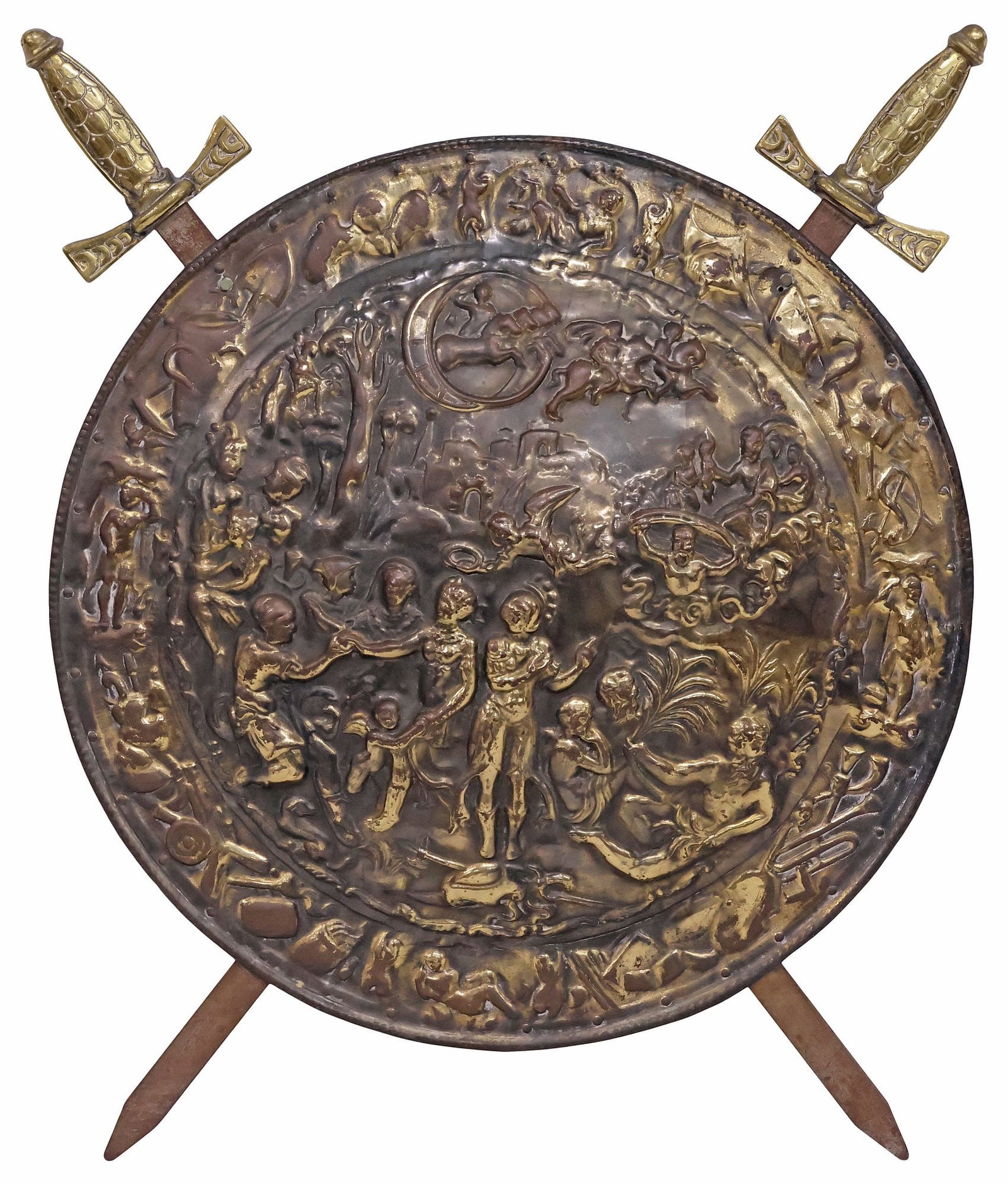 LARGE DECORATIVE BRASS REPOUSSE SHIELD & SWORDS RELIEF PLAQUE: Decorative English brass repousse wall plaque, 20th c., two crossed iron swords centering a round shield, repousse scene with overlapping allegorical figures and cherubs in low relief, approx 27"h, 22