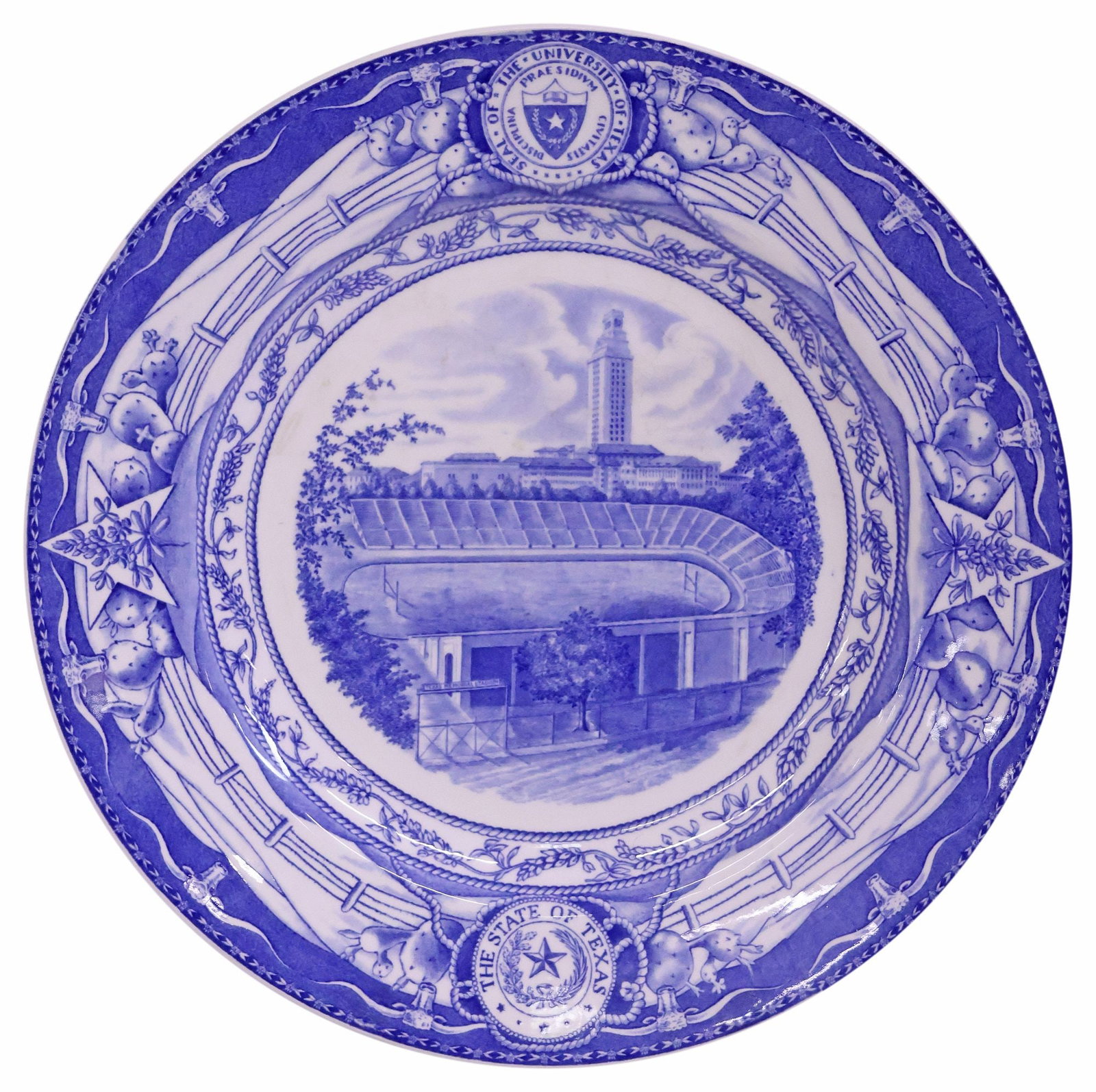 SCARCE BLUE WEDGWOOD UT 'MEMORIAL STADIUM' COMMEMORATIVE PLATE: Scarce Wedgwood commemorative University of Texas at Austin plate, blue on a white ground, a detailed transfer of "Memorial Stadium," a rope and bluebonnet design frame the scene with the University o