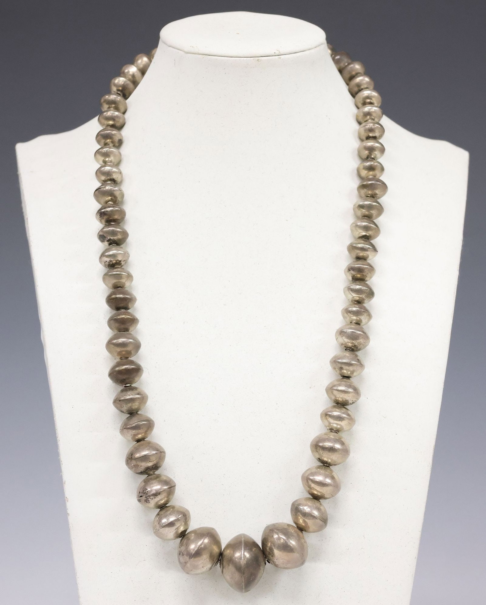NAVAJO PEARLS SILVER GRADUATED BENCH BEAD NECKLACE: Native American silver (content unknown) necklace, likely Navajo/ Dine, fifty-three graduated bench beads, with hook closure, approx 23.5"l, 79.5 grams (inclusive of all materials) **Provenance: The D