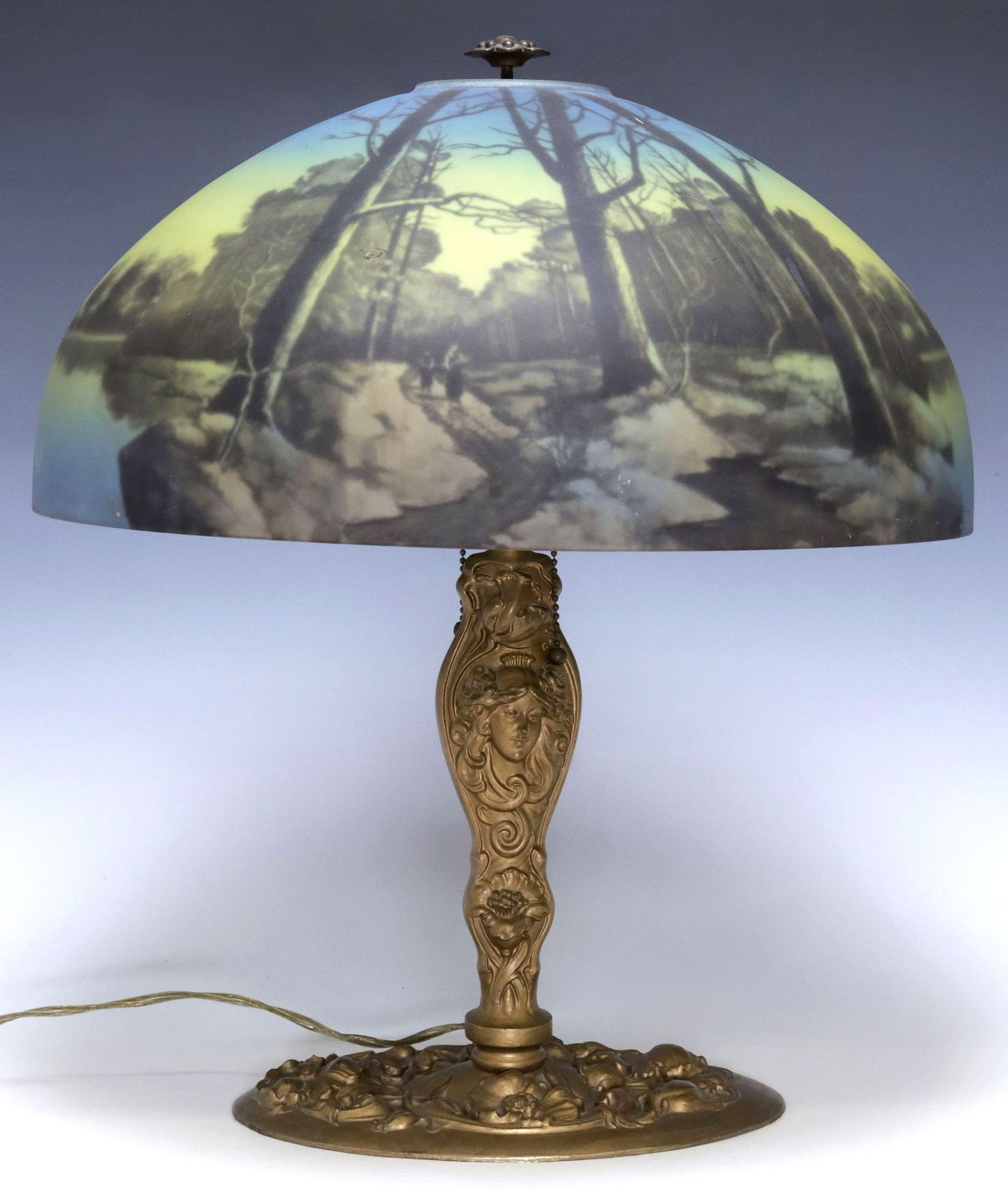 PITTSBURGH LAMP CO. (ATTRIB.) REVERSE-PAINTED GLASS 2-LT TABLE LAMP: Art Nouveau style gilt-metal and art glass two-light table lamp, attributed to Pittsburgh Lamp, Brass & Glass Company, c.1920s, floriform finial, over domed shade with reverse-painted winter landscape