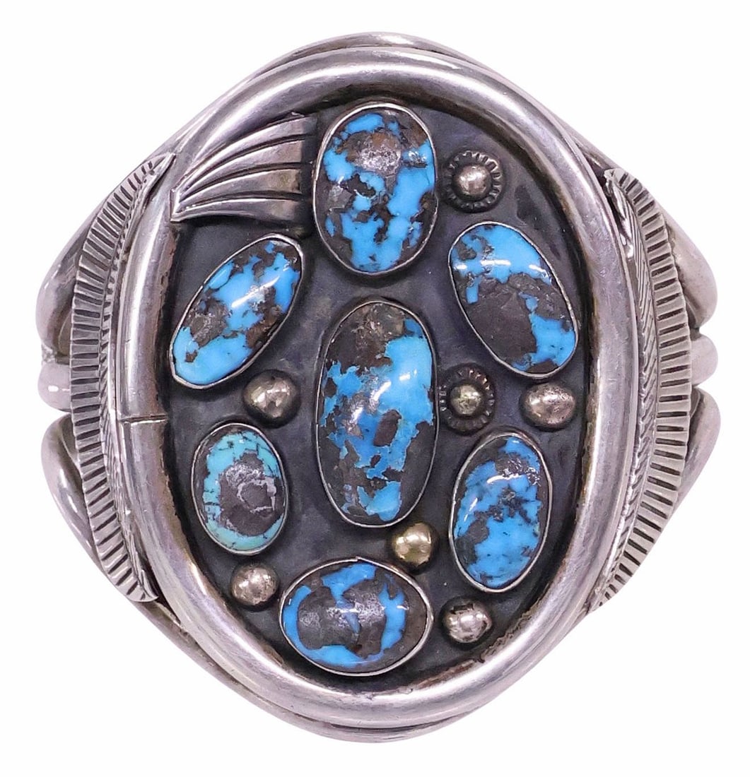 PHILLIP TSO (20TH C.) NAVAJO SILVER & TURQUOISE CABOCHON CUFF BRACELET: Native American silver (content unknown) and turquoise cuff bracelet, signed Phil T. (Phillip Tso, Navajo, 20th c.), with seven bezel-set turquoise stones in patinated surround, on split-shank cuff wi