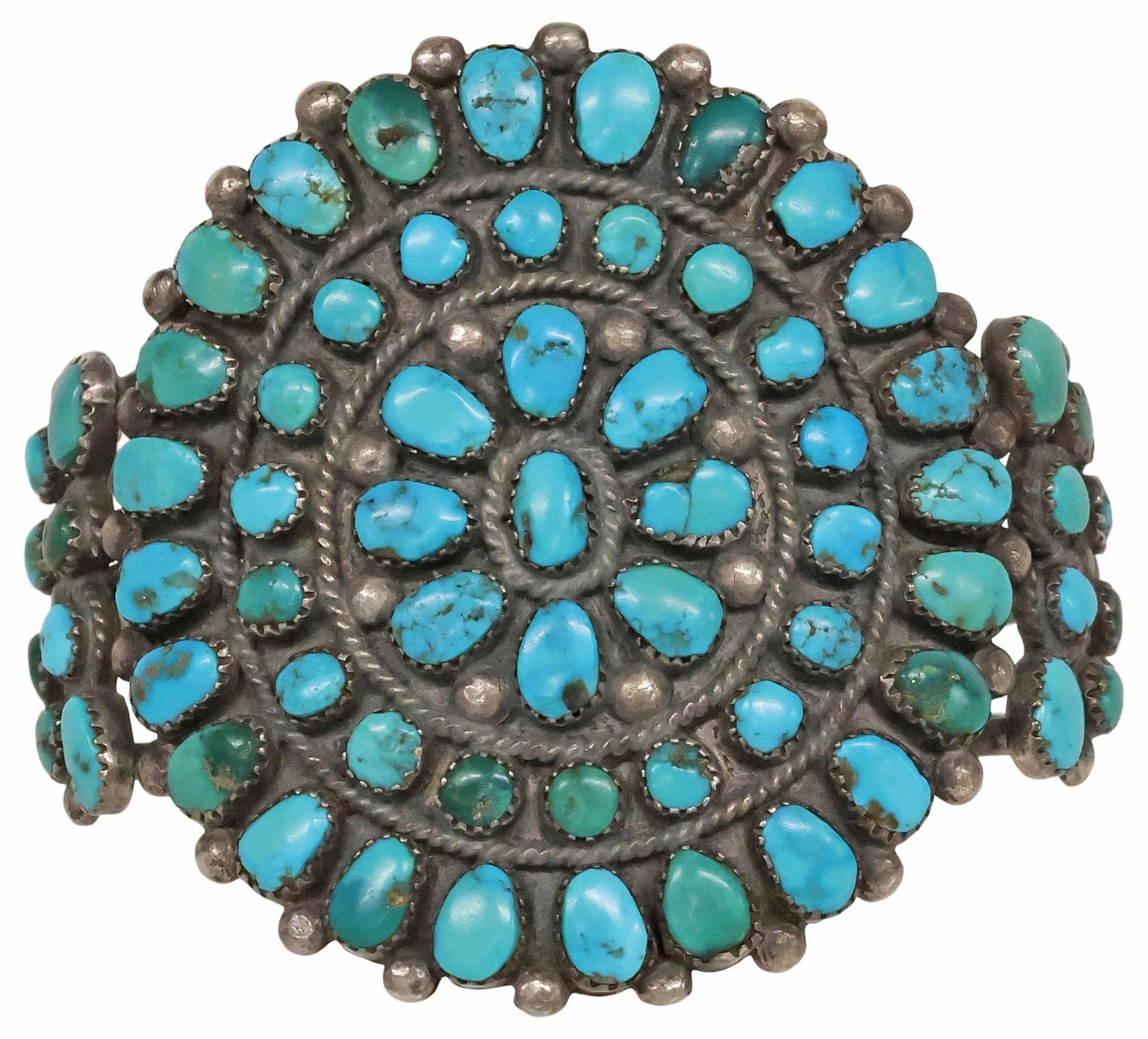 NATIVE AMERICAN SILVER & TURQUOISE CLUSTER CUFF BRACELET: Native American silver (content unknown) cuff bracelet, central floriform roundel with beaded accents and two concentric bands set with fifty-one small turquoise cabochons, either side of split shank 