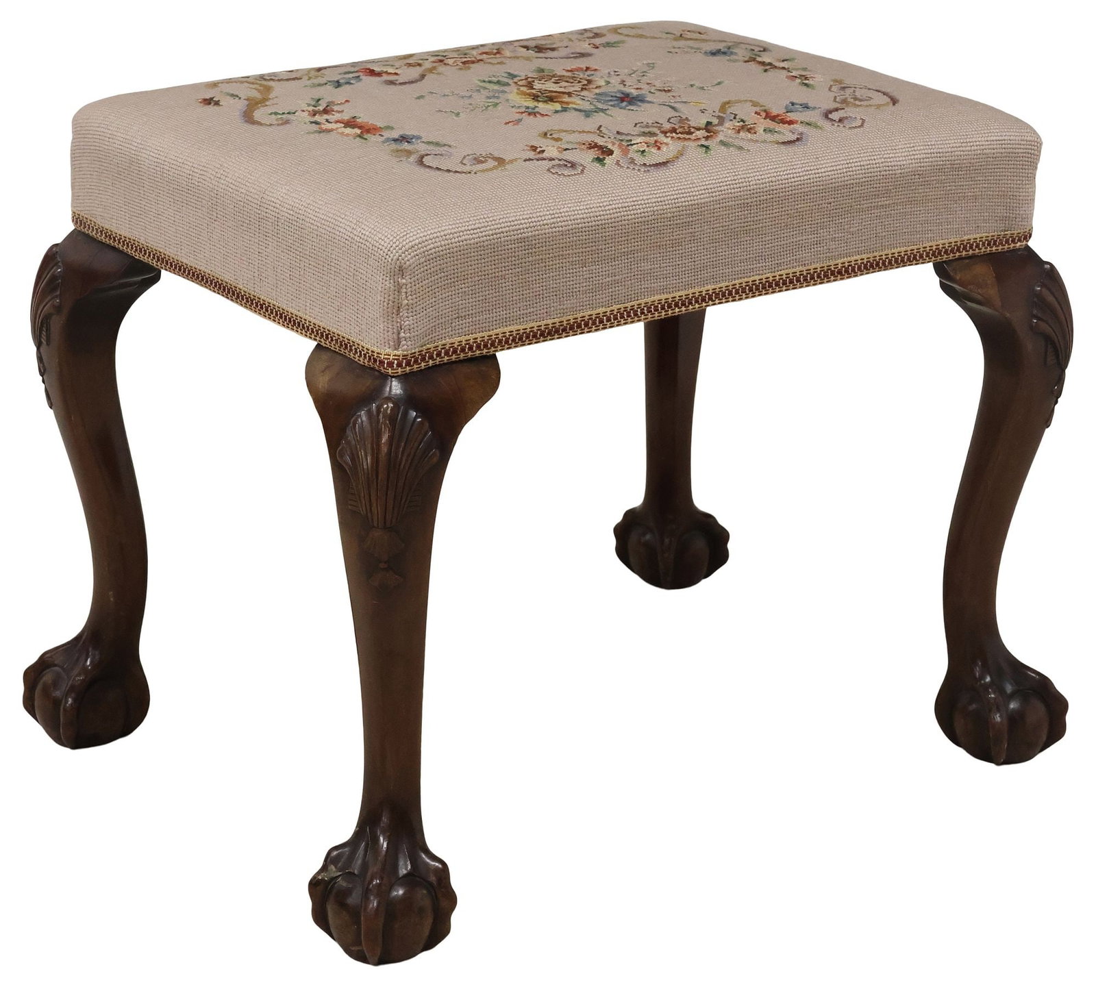 ENGLISH CHIPPENDALE STYLE NEEDLEPOINT & MAHOGANY VANITY STOOL: English Chippendale style mahogany vanity/ dressing bench, early 20th c., padded seat in a floral needlepoint upholstery, with applique trim, rising on cabriole legs headed by carved shell motifs, end