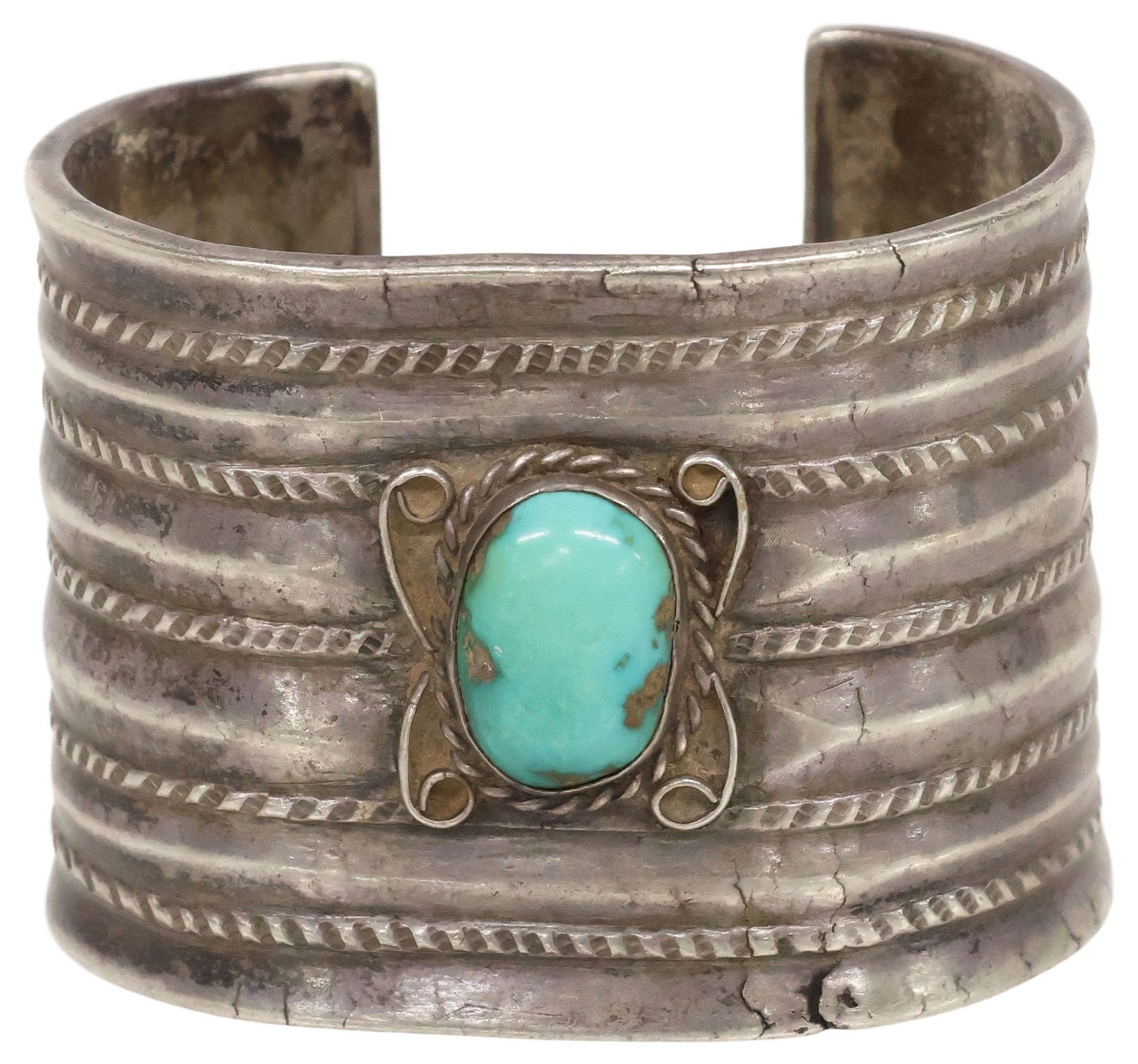 HEAVY NATIVE AMERICAN SILVER & TURQUOISE CUFF BRACELET, 149 GRAMS: Native American silver (content unknown) cuff bracelet, with six raised rows, spaced by registers of stamped rope twist design, centering oval turquoise cabochon flanked by scrolled filagree, unmarked
