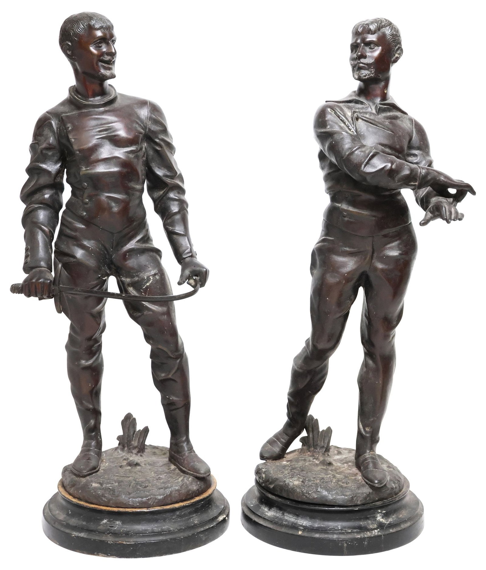 (2) PATINATED SPELTER FIGURAL SCULPTURES, THE FENCERS: (lot of 2) Patinated spelter figural sculptures, The Fencers, each signed in cast Arhie?, including: (1) depicting a man smiling, holding a sword, on non-integral wood base, figure: approx 23.75"