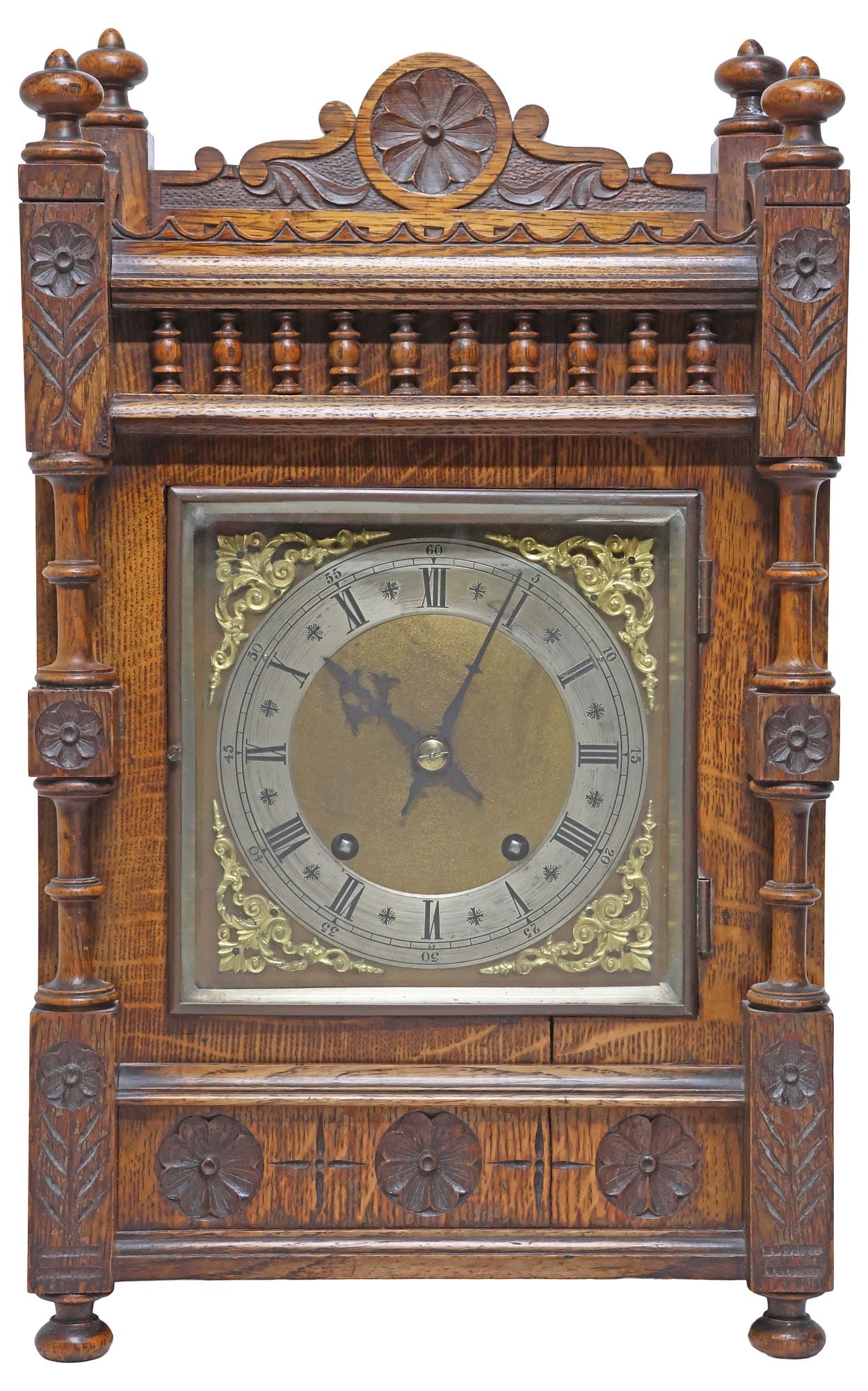 ENGLISH VICTORIAN CARVED OAK MANTEL SHELF CLOCK: English Victorian carved oak mantel clock, late 19th c., spindled rectangular case with turned finials and raised gallery, centering floral roundel, over glazed door revealing metal dial with Roman nu