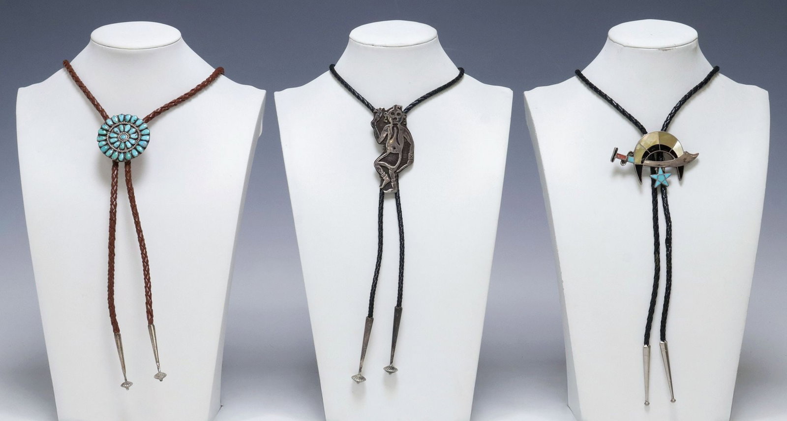 (3) NATIVE AMERICAN SILVER & GEMSTONE BOLO TIES, 1 WATSON HONANIE: (lot of 3) Native American silver (content unknown) bolo ties, each with silver tips, on braided leather cord, including: (1) signed WH (Watson Honanie, Hopi, 20th c.), silver overlay ornament in the 