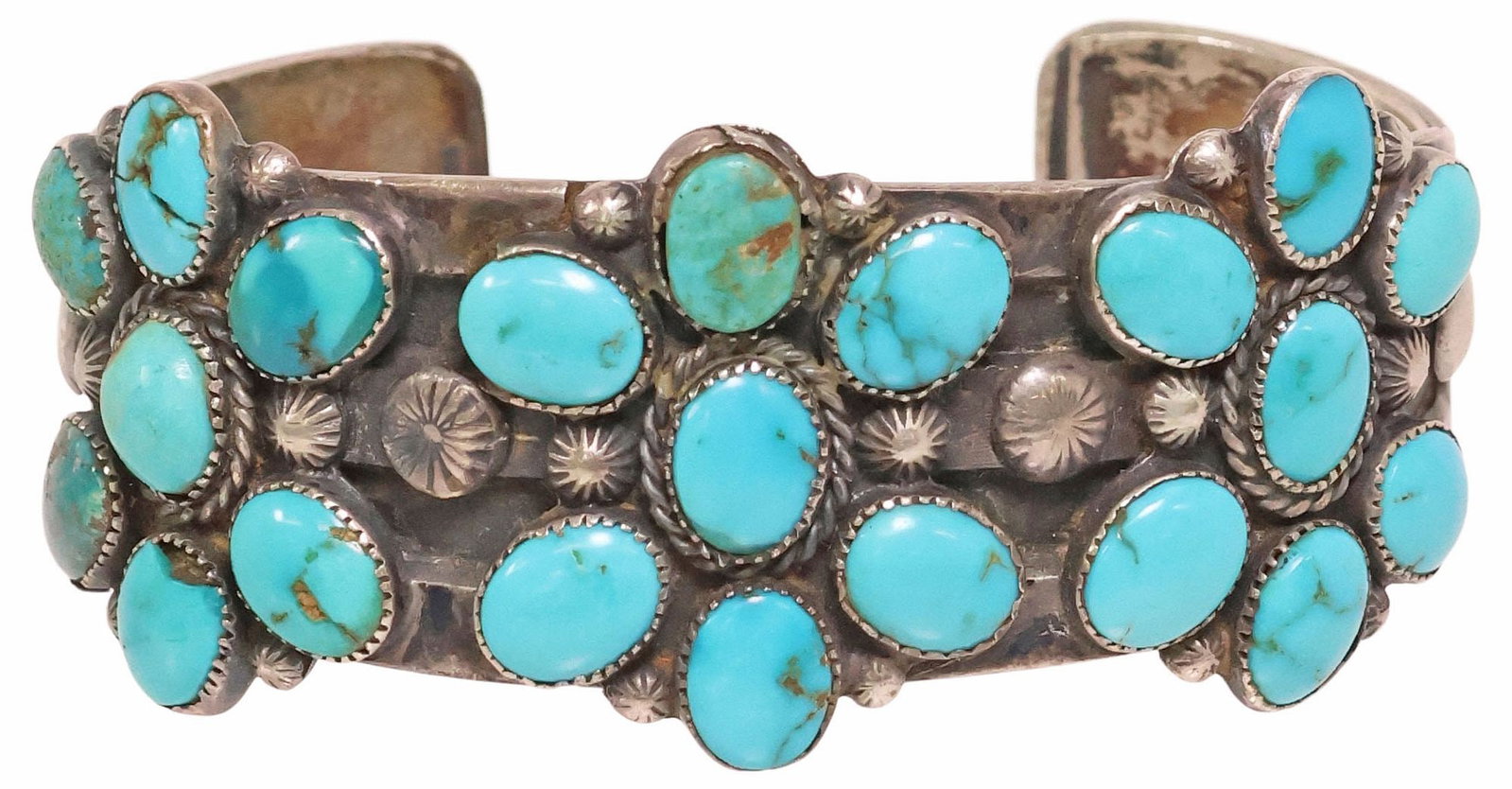 NATIVE AMERICAN SILVER & TURQUOISE STAMPWORK CUFF BRACELET: Native American silver (content unknown) cuff bracelet, comprising twenty-one turquoise cabochons bezel-set in the form of three flowers, beaded and stampwork accents, unmarked, stones intact with hai